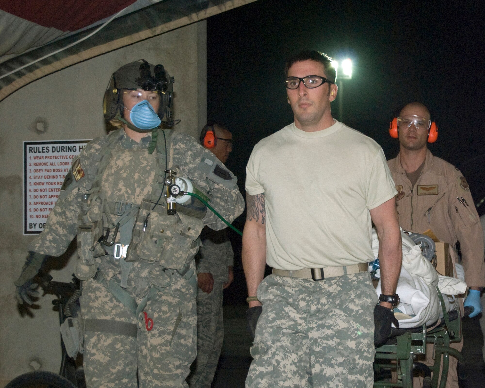 A UH-60 Blackhawk crewmember with the Texas National Guard's 2-149th General Support Aviation Battalion accompanies Mike Zajicek and Capt. Hunter Letchman as they wheel a patient through Hero's Highway and into the emergency room at Joint Base Balad, Iraq, Oct. 22. The patient was aeromedically evacuated to Balad via a UH-60 Blackhawk helicopter. Mr. Zajicek, a facility inspector with the 402nd Army Field Support Brigade, is deployed from the Army Research Laboratory at Aberdeen Proving Ground, Md., and has approximately 300 volunteer hours. Capt. Letchman, the 332nd Air Expeditionary Wing deputy chief of flight safety, is deployed from Columbus Air Force Base, Miss., and has approximately 20 volunteer hours. (U.S. Air Force photo/Staff Sgt. Don Branum) 