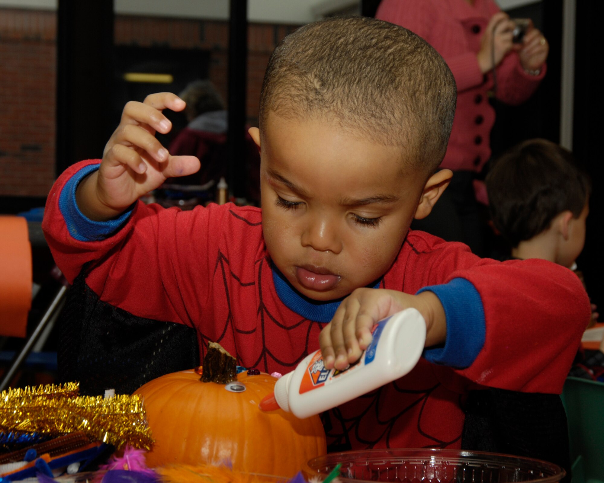 HANSCOM AIR FORCE BASE, Mass. – Just a little more glue will do the trick for Malik Neufuille, as he decorates his pumpkin during a Child Development Center family activity on Oct. 28. During the event families enjoyed a visit to the pumpkin patch, as well as cider and donuts. The CDC sponsors many events throughout the year for families enrolled in the Center to enjoy time together. (U.S. Air Force photo by Linda LaBonte Britt)

