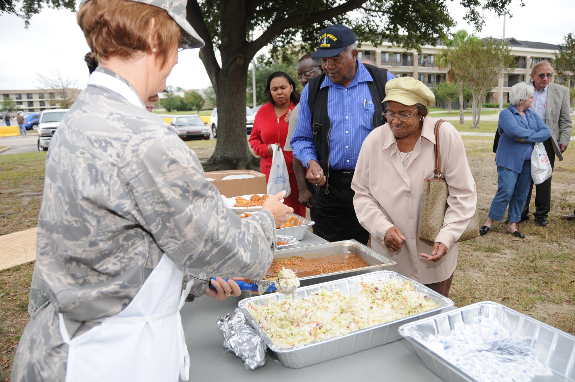 Lt. Col. Elizabeth Watson, 81st MDTS, serves retired Tech. Sgt. Percy Quinn and his wife, Dorothy, some coleslaw at a fish fry honoring retirees.  Mr. and Mrs. Quinn are from Tylertown, Miss.  (U.S. Air Froce photo by Kemberly Groue)