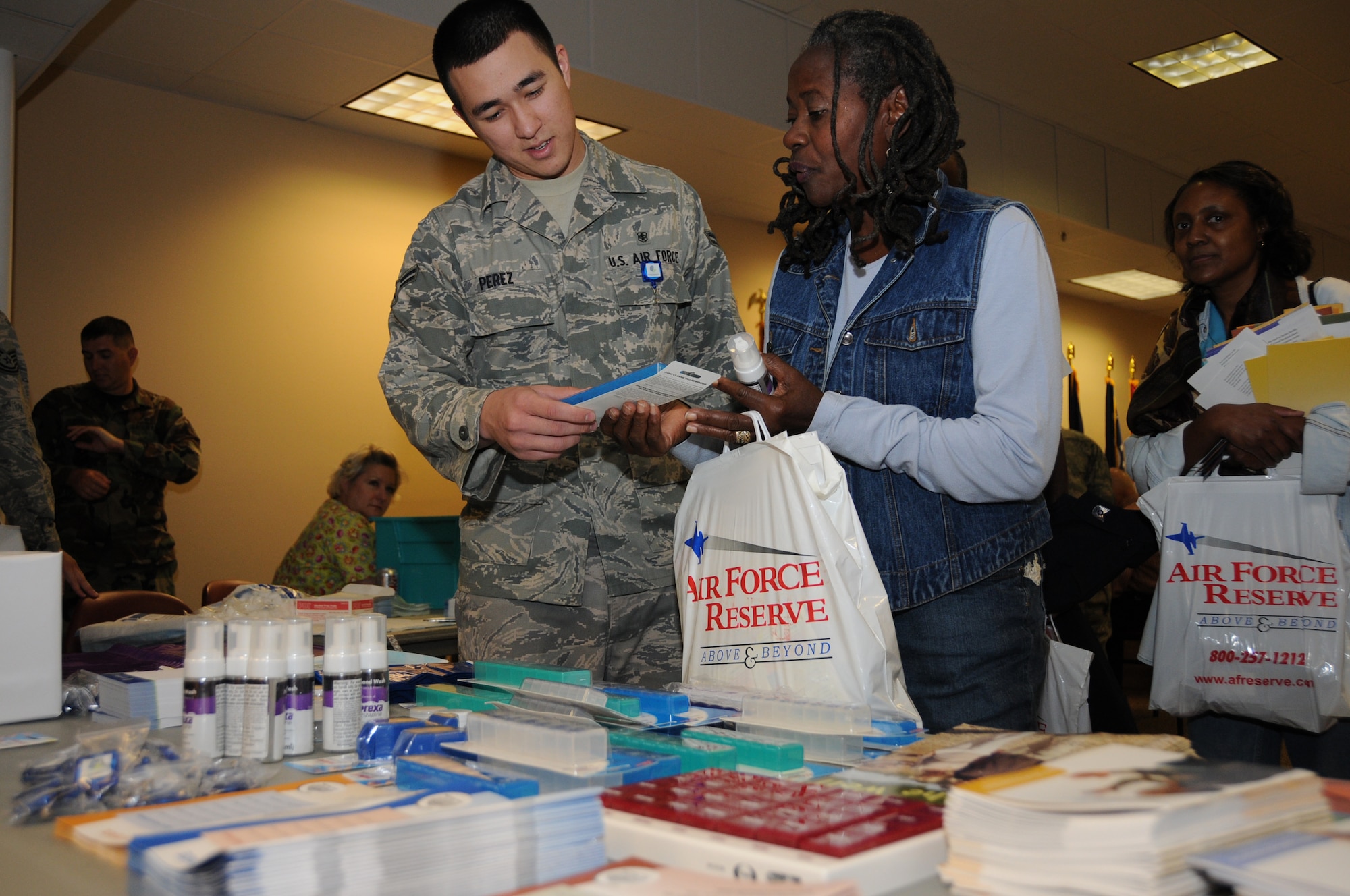 Airman 1st Class Richard Perez, 81st Diagnostics and Therapeutics Squadron, gives Ruthie Lawrence of St. Martin, some pamphlets and free samples at the pharmacy table.  Mrs. Lawrence’s late husband, Leon, was a retired technical sergeant.  (U.S. Air Force photo by Kemberly Groue)