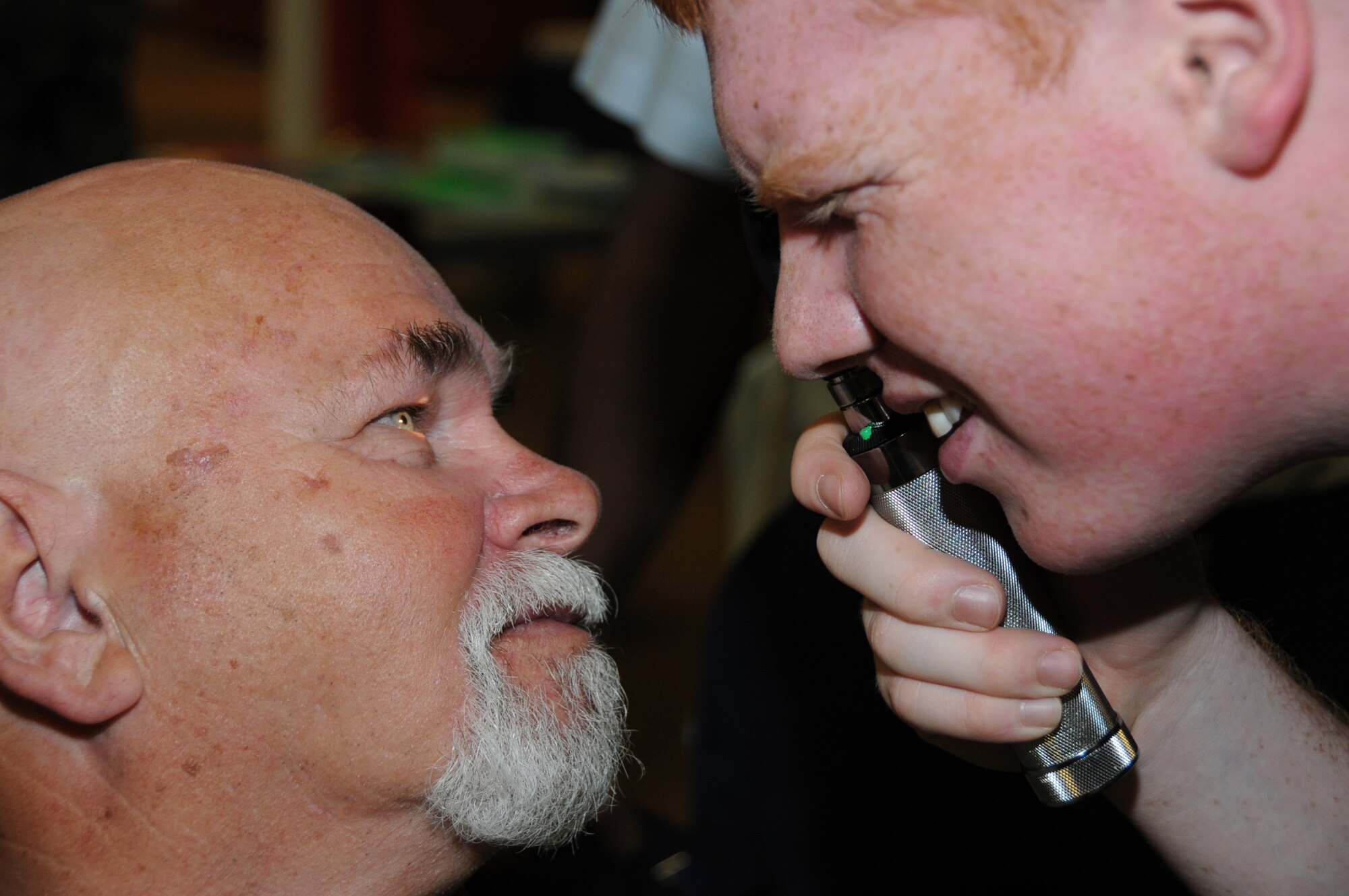 Retired Master Sgt. Ronney Spradlin, a civilian in the 81st Logistics Readiness Squadron, has his eyes examined by Airman 1st Class Chris Simpson, 81st Surgical Operations Squadron, at Retiree Appreciation Day, Friday at the Locker House Dragon’s Den.  (U.S. Air Force photo by Kemberly Groue)
