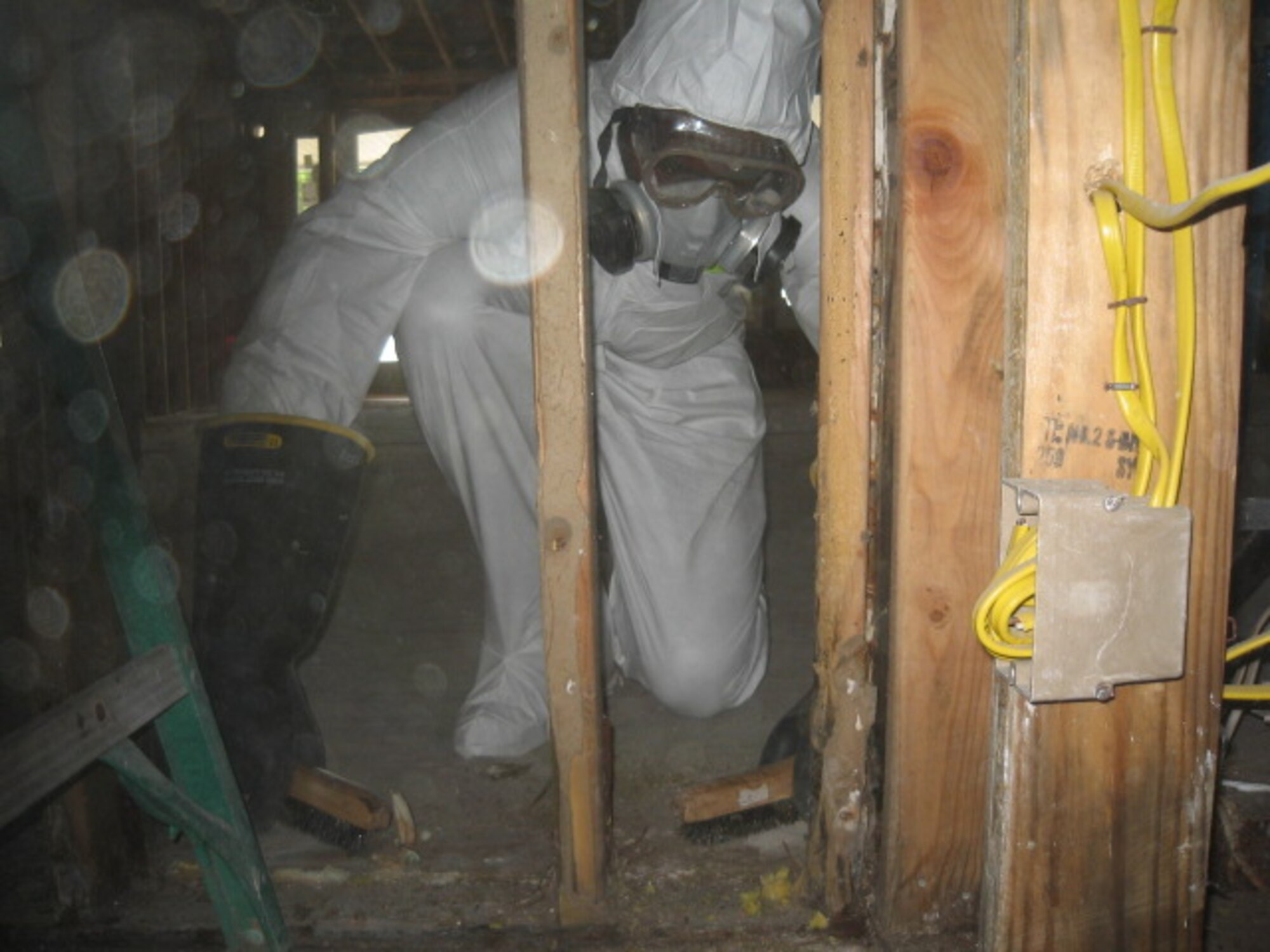 Airman 1st Class Jeremy Grant of the 338th Training Squadron, uses a wire brush to remove mold from frame work of a flood-damaged home in Pearlington, Miss. (Courtesy photo)