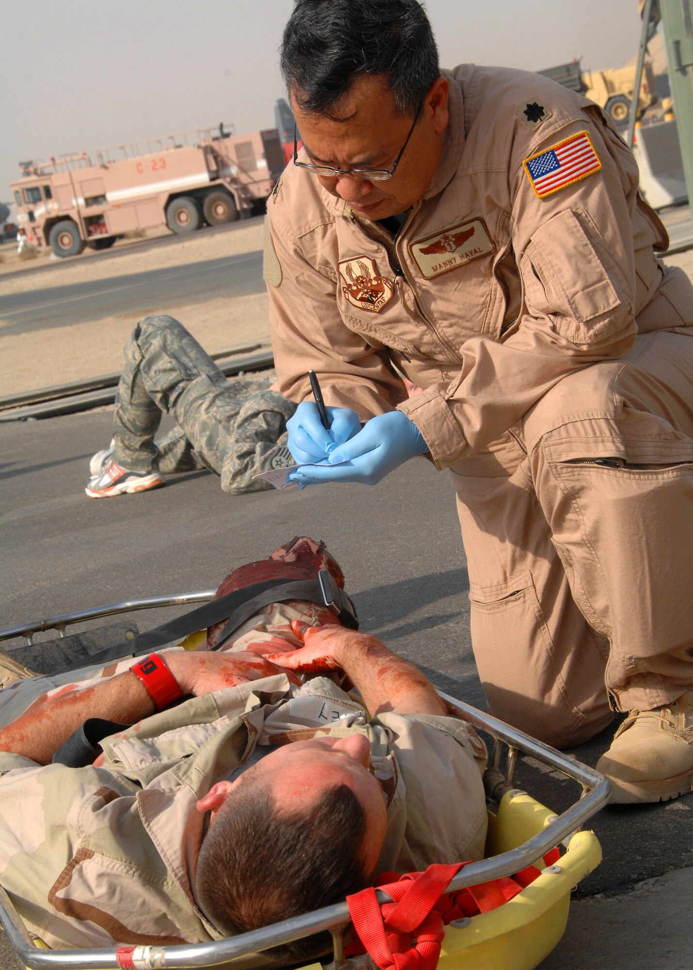SOUTHWEST ASIA -- Lt. Col Manny Naval, 386th Expeditionary Medical Group, writes down vital information on a simulated accident victim during a mass casualty exercise on Oct. 29 at an air base in Southwest Asia. The exercise tested the 386th Air Expeditionary Wing's ability to respond to a major accident in a deployed environment. (U.S. Air Force photo/Tech. Sgt. Raheem Moore)