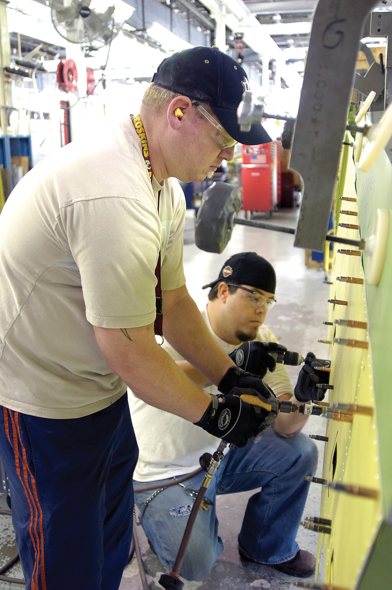 Sheet metal mechanics, Jody Lee and Jason Kramer, re-skin a KC-135 elevator in Bldg. 2121, known as the Sawtooth Building.  The old building isn’t air conditioned and has lots of windows, which allow plenty of of light, but also too much summer heat. In fiscal year 2009, sheet metal, TF33 engine and Defense Logistics Agency employees will be the first to call the new Tinker Aerospace Complex home.(Air Force photo/Margo Wright)