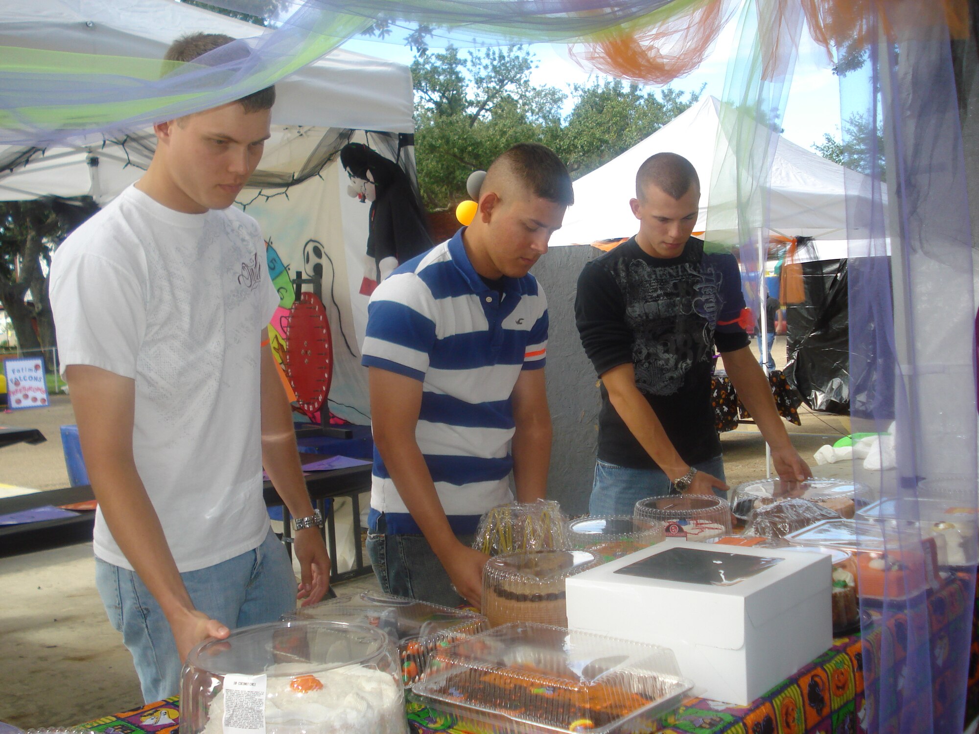 From left, Airman Basic Charles Beaver, Airman Randall Ciardetti and Airman Basic Cody Trenda, 336th Training Squadron students, help set up booths at Our Lady of Fatima School’s Halloween carnival in Biloxi.  (U.S. Air Force photo by Staff Sgt. Carlos Rodriguez)