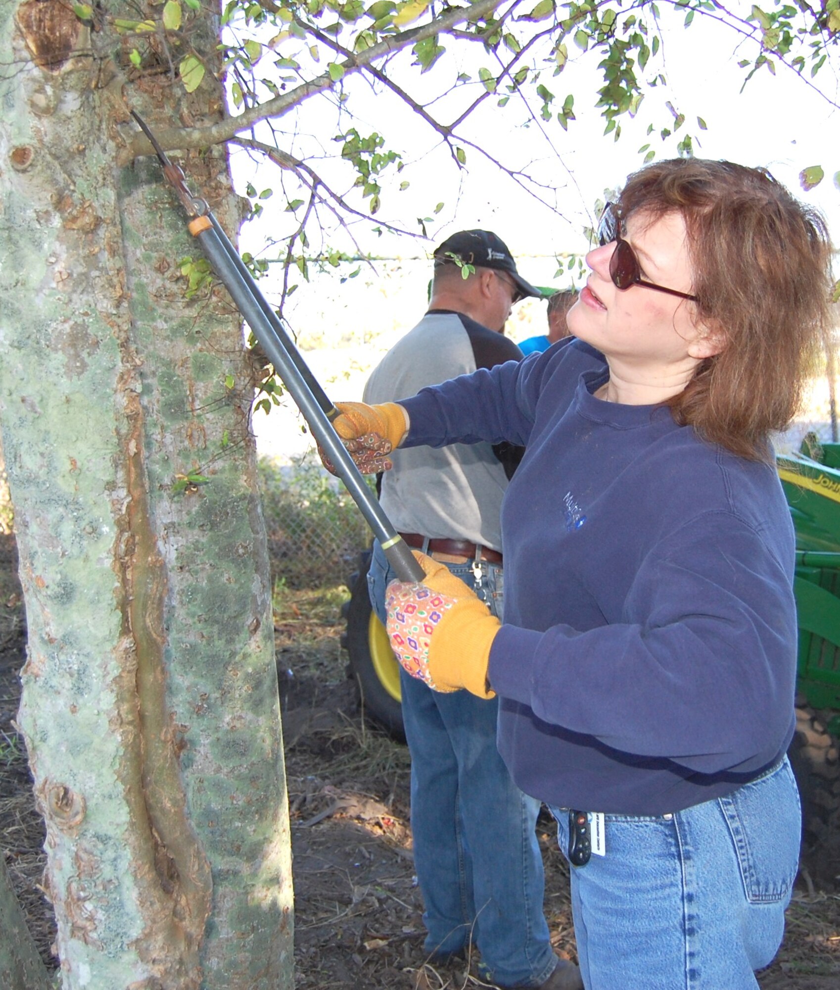 Capt. Elaine Caudill, 81st Surgical Operations Squadron, trims a tree in an area being converted into a park in east Biloxi.  Base volunteers planted flowers, installed benches, created a walkway and set out trash cans.  (U.S. Air Force photo by Steve Pivnick)