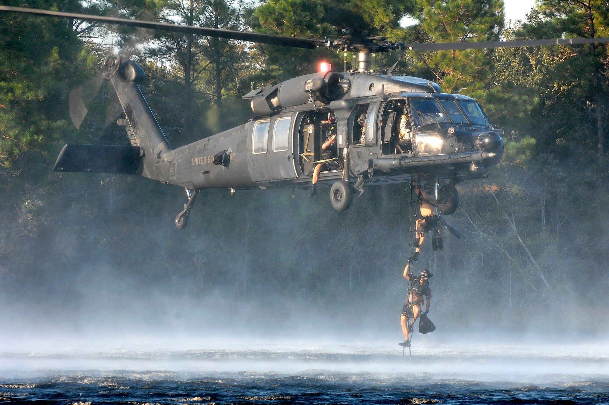 After completing zodiac deployment training, pararescuemen from the 23rd Special Tactics Squadron climb a ladder into a U.S. Army MH-60 Blackhawk over Gator Lake, Fla., Oct. 16 near Hurlburt Field.  Boarding via the ladder saves critical moments that may be needed in a rescue. (U.S. Air Force photo/Senior Airman Julianne Showalter) 
