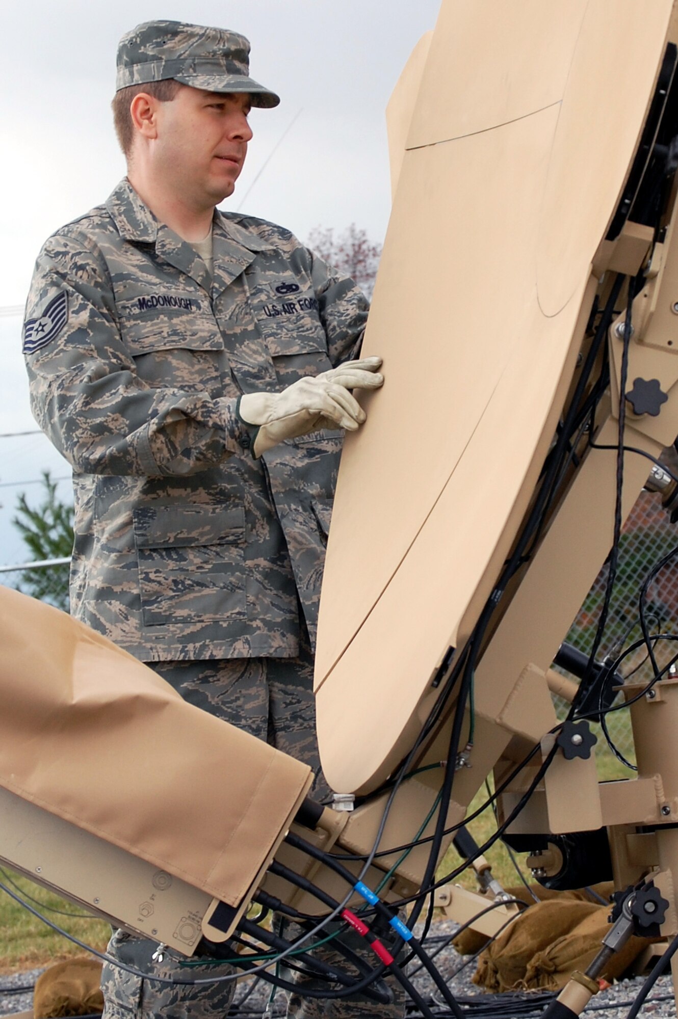 Tech. Sgt. Adrian McDonough, course director for the U.S. Air Force Expeditionary Center's Small Package Initial Communications Element, or SPICE, Course, prepares a satellite dish used in a SPICE package for training in the Mobility Operations School's mobile command, control and communications training facility on the Expeditionary Center campus Oct. 29, 2008, on Fort Dix, N.J.  The SPICE Course is a new course in the MOS starting in February 2009.  (U.S. Air Force Photo/Tech. Sgt. Scott T. Sturkol) 