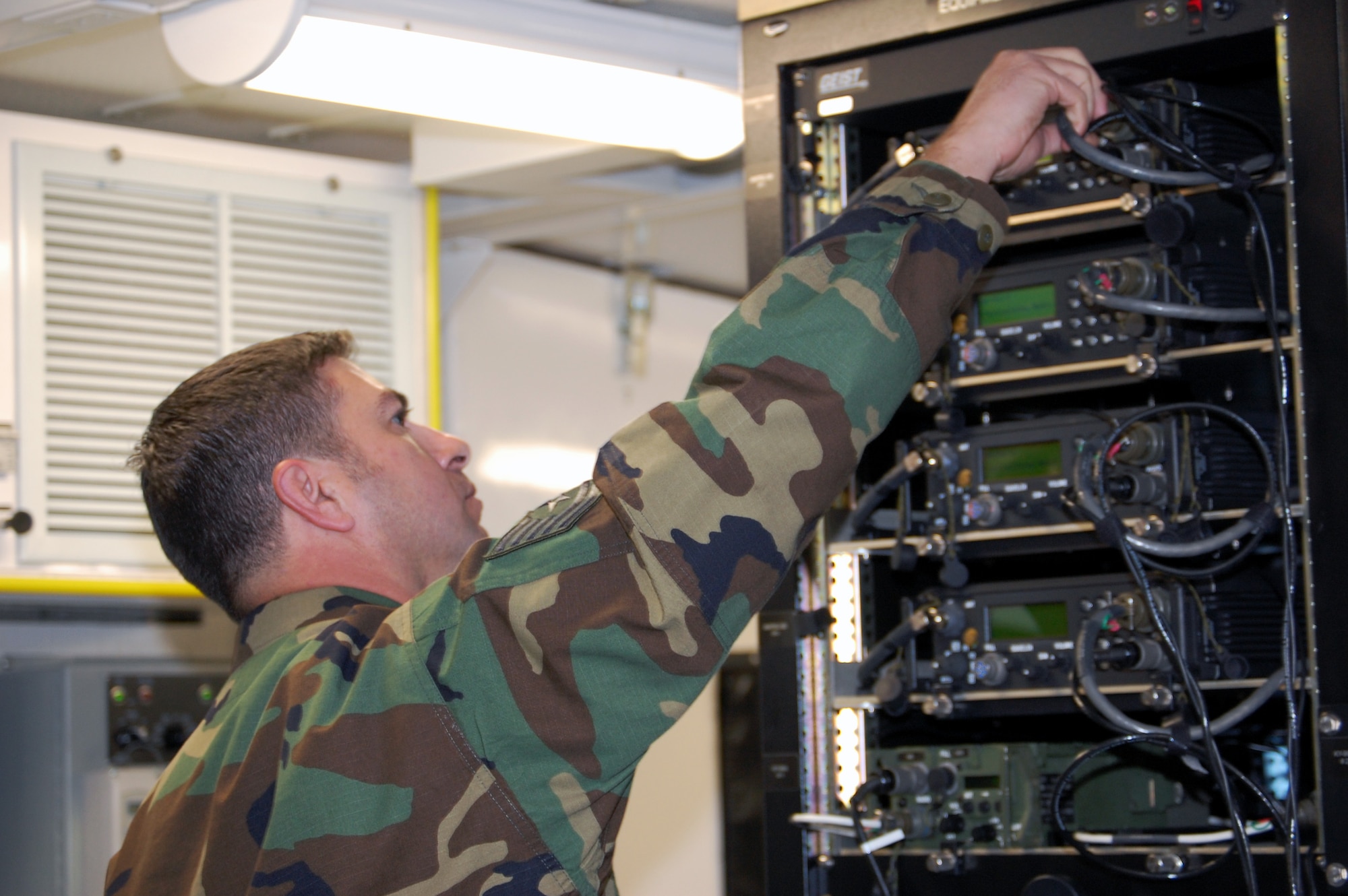 Tech. Sgt. Don Colbert, course director for the U.S. Air Force Expeditionary Center's Mobile Command, Control and Communications Systems Course, works on radio equipment inside the Hard-sided Expandable Lightweight Air Mobile Shelter, or HELAMS, in the Mobility Operations School's Mobile C3 training facility on Fort Dix, N.J., Oct. 29, 2008.  The HELAMS is the Air Force's newest shelter being fielded to contingency response forces to serve as mobile command posts in a bare-base environment.  (U.S. Air Force Photo/Tech. Sgt. Scott T. Sturkol)