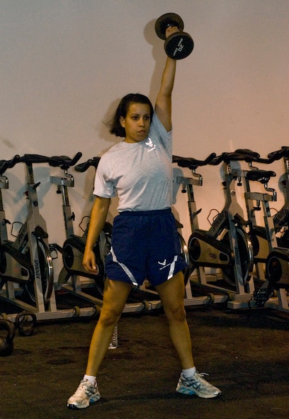 Staff Sgt. Monica France lifts a dumbbell above her head as part of a CrossFit workout in the Red Tail Fitness Center at Joint Base Balad, Iraq, Oct. 30. Faced with a possible medical discharge from the Air Force, France discovered the program, which not only saved her career but improved her overall health. When not working as a personnel journeyman at the 332nd Expeditionary Security Forces Group, France teaches these fitness classes to servicemembers. France is a native of Brooklyn, N.Y., deployed from the 820th Security Forces Group at Moody Air Force Base, Ga. (U.S. Air Force photo/Tech. Sgt. Erik Gudmundson)