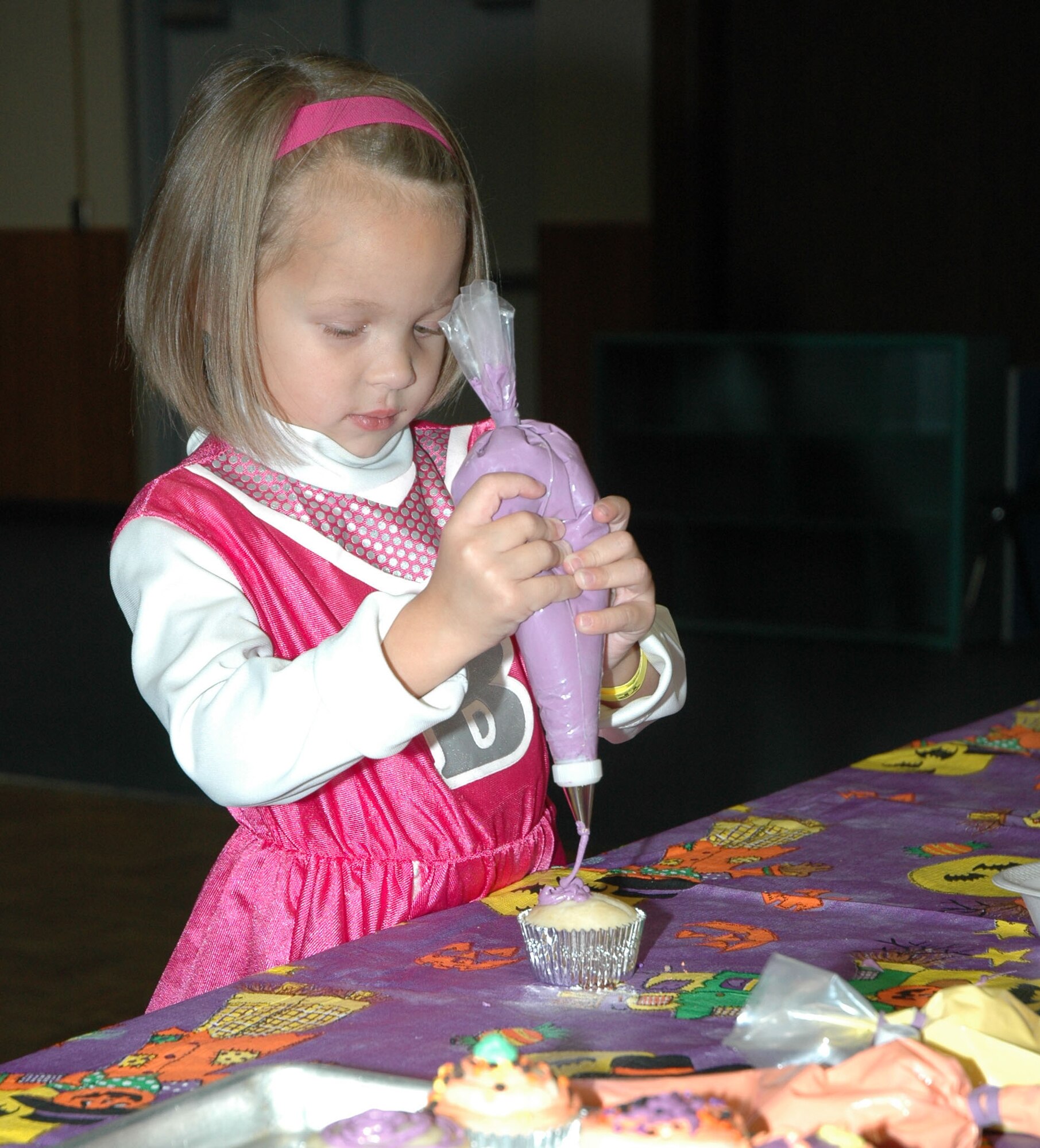 Little Warrior Hailey, 4, adds icing to a cupcake during the Fall Festival Oct. 24 at the Youth Program Center. (U.S. Air Force photo/Airman 1st Class Dillon White)