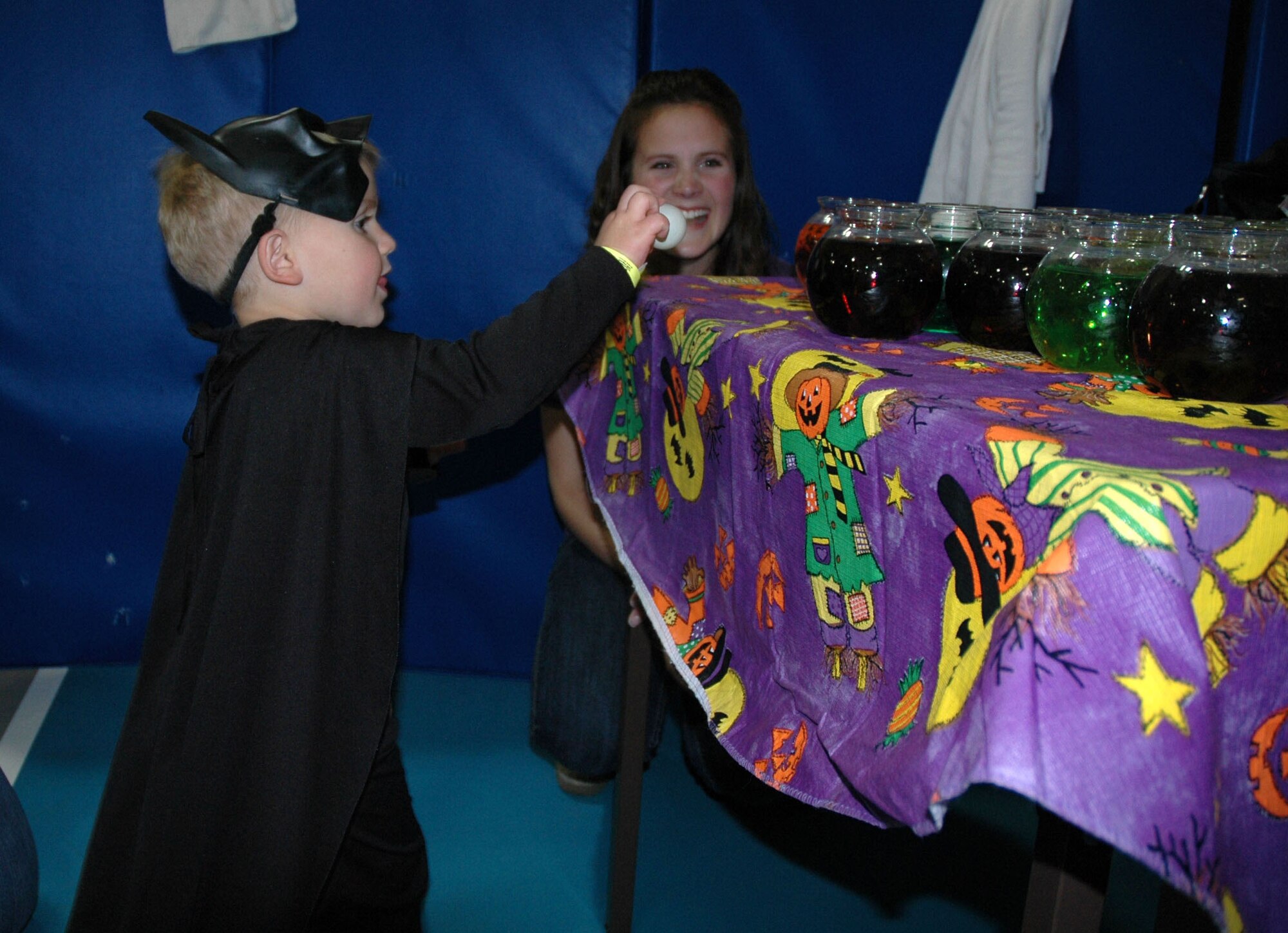 Little Warrior Joshua, 3, lines up a ping-pong ball with his intended fish-bowl target to win a prize during the Fall Festival Oct. 24 at the Youth Program Center. (U.S. Air Force photo/Airman 1st Class Dillon White)