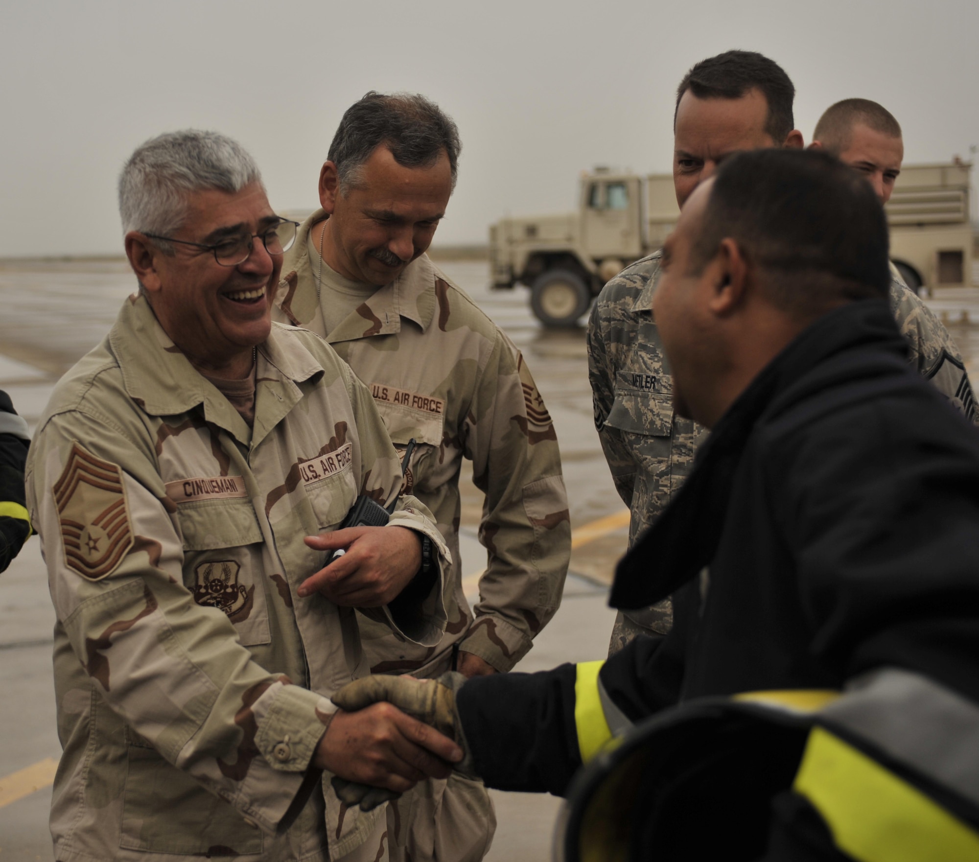 10/29/2008 ? NEW AL MUTHANA AIR BASE, Iraq - Chief Master Sgt. John Cinquemani, 447th Expeditionary Civil Engineer Squadron fire chief, congratulates Iraqi air force firefighters on their accomplishments during a combined American Iraqi training exercise. The chief is deployed from the 105th Airlift Wing at Stewart Air National Guard Base in New York, where he serves as the full-time fire chief for the base as well as Stewart International Airport. (U.S. Air Force photo by Master Sgt. Brian Davidson)