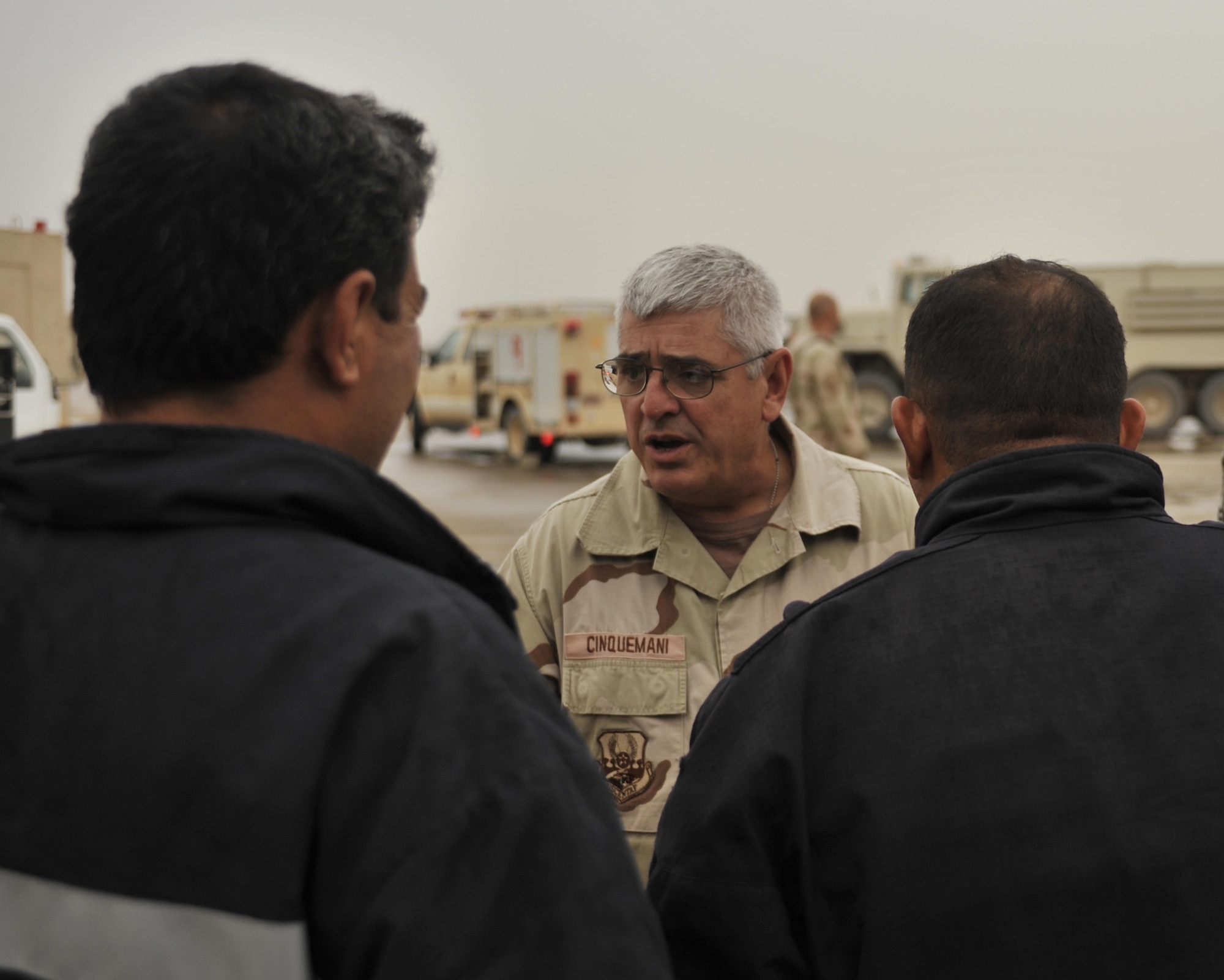 10/29/2008 ? NEW AL MUTHANA AIR BASE, Iraq - Chief Master Sgt. John Cinquemani, 447th Expeditionary Civil Engineer Squadron fire chief, talks with Iraqi air force firefighters about how they did during a combined American Iraqi training exercise. The chief is deployed from the 105th Airlift Wing at Stewart Air National Guard Base in New York, where he serves as the full-time fire chief for the base as well as Stewart International Airport. (U.S. Air Force photo by Master Sgt. Brian Davidson)