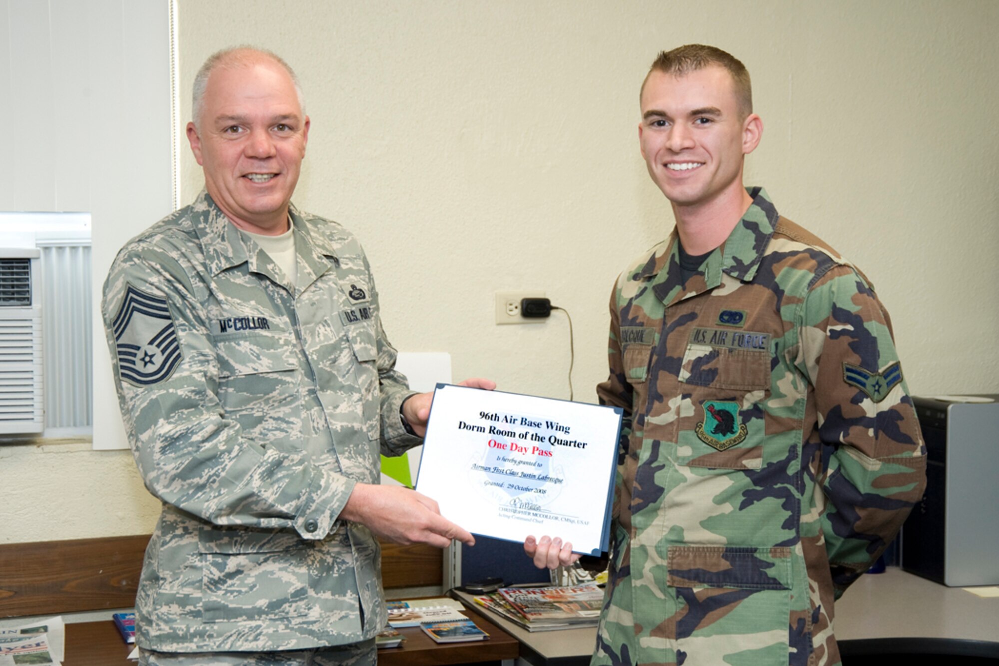 EGLIN AIR FORCE BASE, Fla. -- Chief Master Sgt. Christopher McCollor, 96th Mission Support Group, presents a certificate for a one-day pass to Airman First Class Justin Labrecque. Airman Labrecque was chosen by the Chiefs Group to receive the award for Room of the Quarter. (USAF photo/Debbie Haussermann)