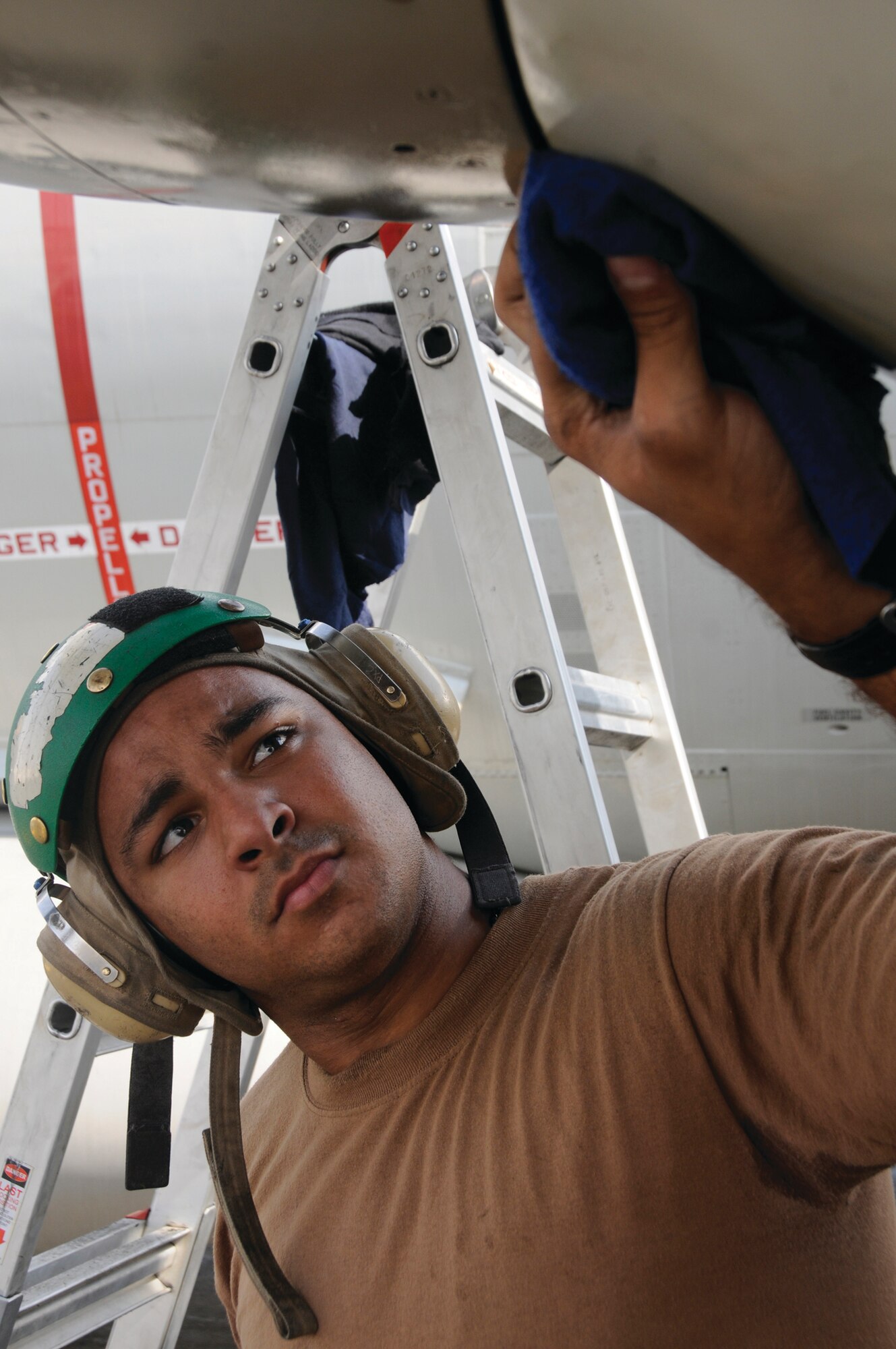 Aviation Machinist Mate Airman Eric Dejesus, assigned to VG CMO 10, uses a towel to clean off a P-3 Orion engine after maintenance has been performed to the aircraft Oct. 27, 2008, at an undisclosed location in Southwest Asia. These aviation machinists are responsible for providing maintenance to the aircraft to ensure the planes can fly and complete their mission in the Global War on Terror. Airman Dejesus, a native of Orlando, Fla., is deployed from Naval Air Station Whidbey Island, Wash.  (U.S. Air Force photo by Staff Sgt. Darnell T. Cannady)