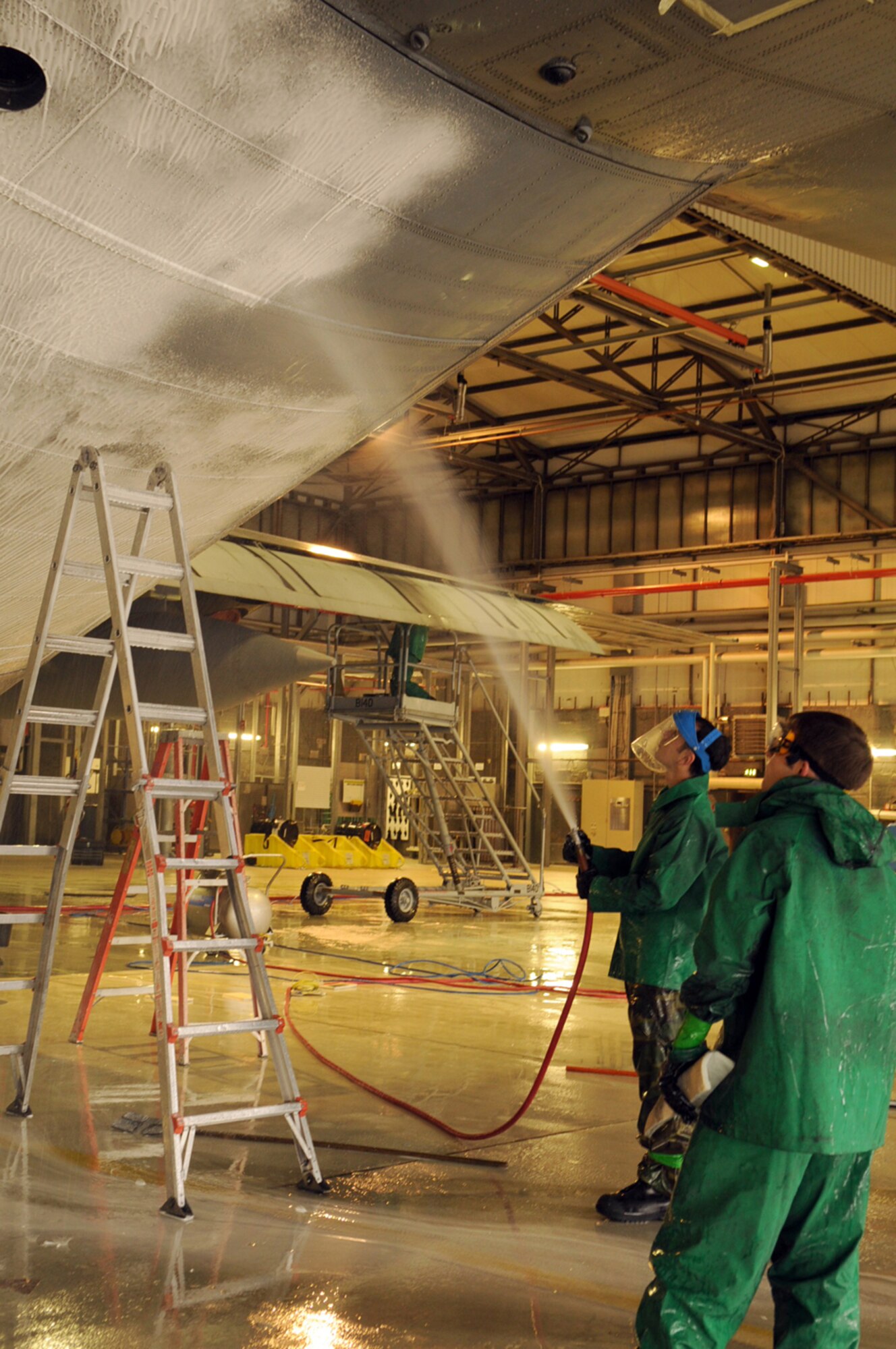 Members from the 86th Aircraft Maintenance Squadron spray a C-130E Hercules with foam to assist with the cleaning process in Hangar 1, Ramstein Air Base, Germany, Oct. 28, 2008. The wash crew is made up of a 12-member team from the 86th AMXS who wash aircraft every 90 days to keep them mission ready. (U.S. Air Force photo by Airman 1st Class Scott Saldukas)