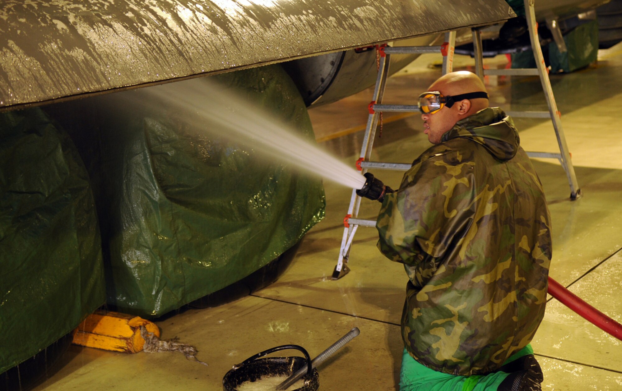 Senior Airman Darrell Bradford, 86th Aircraft Maintenance Squadron crew chief, hoses down a C-130E Hercules in Hangar 1 Ramstein Air Base, Germany, Oct. 28, 2008. The wash crew is made up of a 12-member team from the 86th AMXS who wash aircraft every 90 days to keep them mission ready. (U.S. Air Force photo by Airman 1st Class Scott Saldukas)