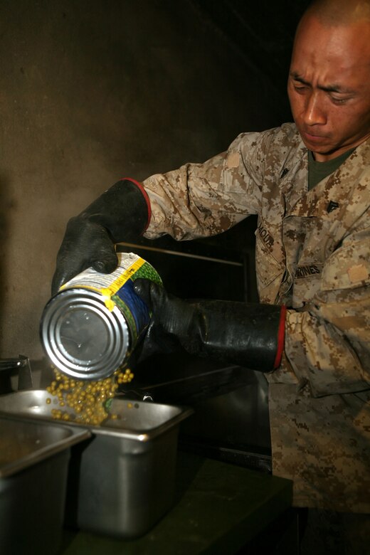 Cpl. Hue Moua, an administration clerk with Provisional Rifle Platoon 3, Regimental Combat Team 5, prepares lunch for hungry Marines at Traffic Control Point 3 in Rawah, Iraq, Oct. 29. Moua said he likes cooking for the Marines because he likes helping people in general, and his efforts in the galley are just one way Moua's initiative has contributed to the success of the platoon.::r::::n::