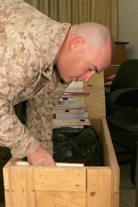 Petty Officer 1st Class Jesse Tossetti, a corpsman with 3rd Bn., 7th Marine Regt., sorts through medical textbooks donated to the Iraqi medical community by the 2nd Class Petty Officers Association at Camp Pendleton, Calif. Tossetti attended the Oct. 30 key leader engagement between Army medical officers from the 345th Combat Support Hospital and the medical staff at Haditha Hospital. Tossetti represented the association and the Navy medical community as he presented the donated texts to the doctors at Haditha Hospital. The texts will help hospital administrators update their medical library.