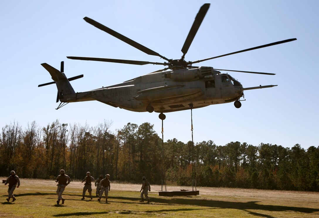 A CH-53 "Super Stallion" lifts a beam, simulating supplies, away from landing support Marines from Landing Support Company, Combat Logistics Regiment 27, 2nd Marine Logistics Group during a Helicopter Support Team operation at Landing Zone Phoenix.  LS Company performs numerous HST's each month for training purposes.