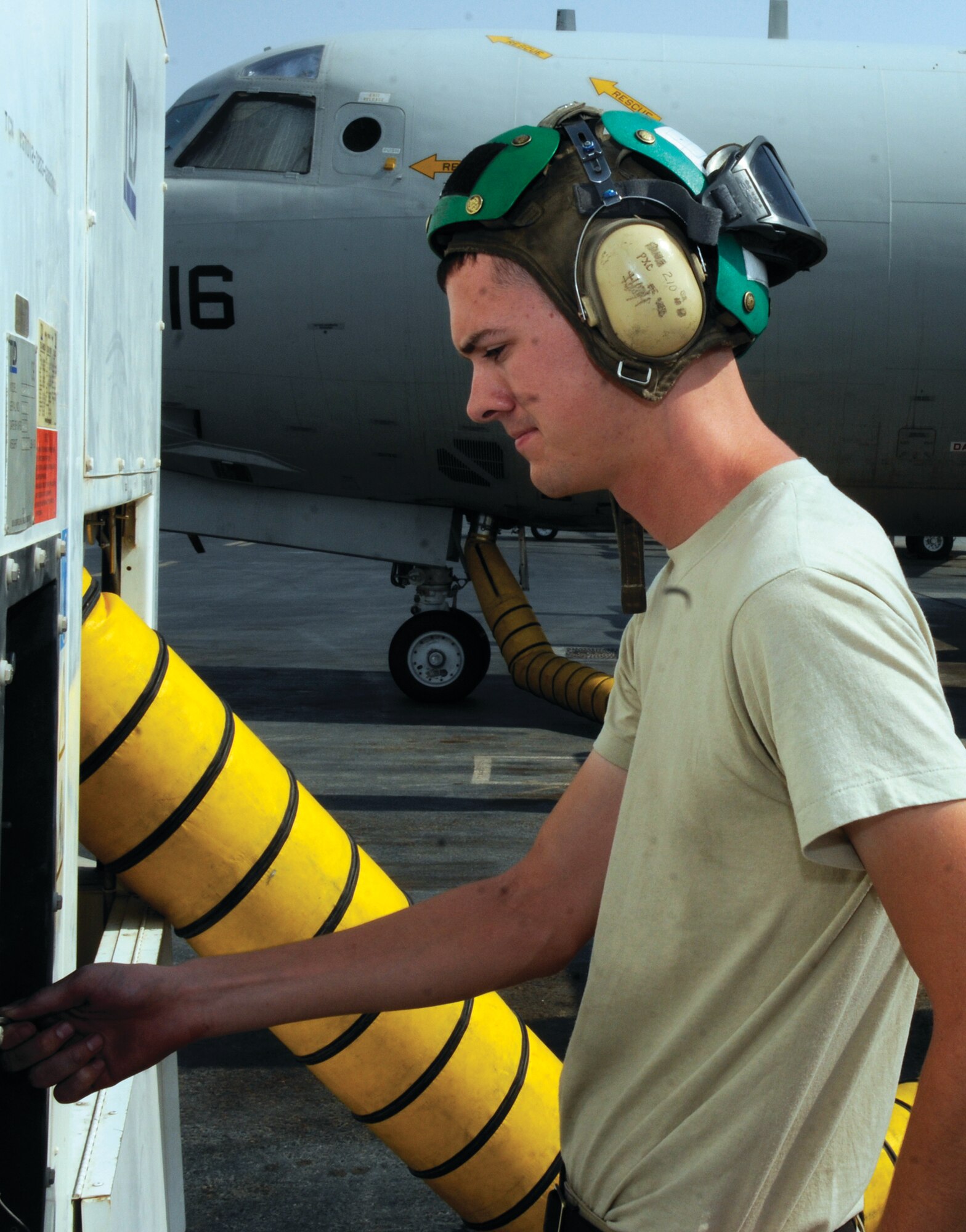 Aviation Electronics Technician 3 Daniel Mayers adjusts an air conditioning cart used for cooling the Navy's P-3 Orion, at a base in Southwest Asia Oct. 16. The P-3C is a land-based, long-range anti-submarine warfare patrol aircraft and provides tactical surveillance, reconnaissance, strike support, fleet support and warning, and monitoring of electromagnetic signals of interest for intelligence analysis. (U.S. Air Force photo/Tech. Sgt. Michael Boquette)