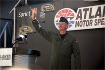 Chief Master Sgt. Lyle Spangler acknowledges cheering spectators at Atlanta Motor Speedway Oct. 26 after the track announcer read a message honoring the 711th Special Operations Squadron aircrew loadmaster's highly decorated, 35-year military service. (Courtesy Photo)