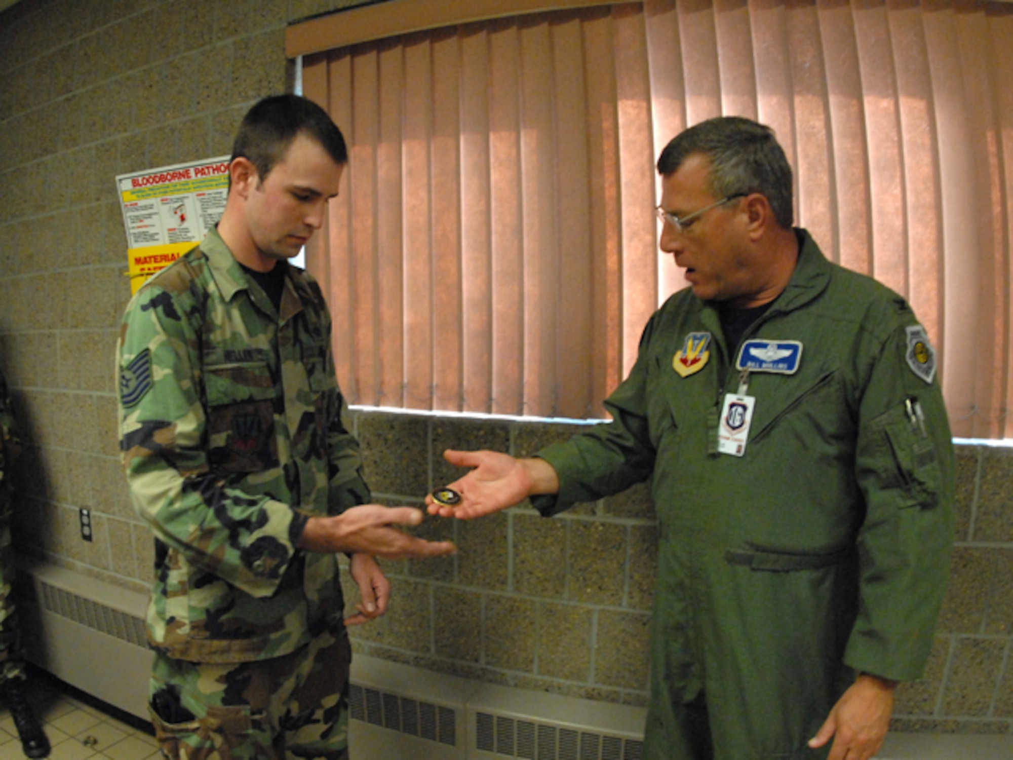 U.S. Air Force Col. William Mullins, right, presents a special unit compliance inspection coin to Tech. Sgt. Levi J. Heller, of the 119th Security Forces Squadron, in recognition of the outstanding work he has done in the combat arms training and maintenance area of the North Dakota Air National Guard. Heller is responsible for procuring, storing and tracking weapons parts for all weapon systems on the installation, which was reported as ‘the best seen to date’ by the unit compliance inspection team.