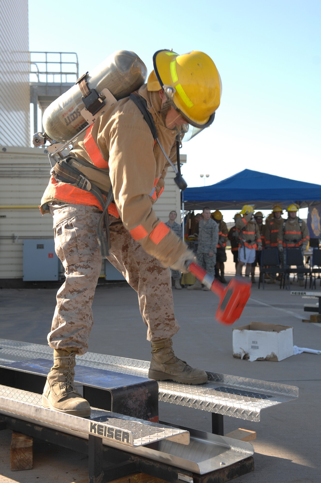 A participant in the 2008 Rookie Firefighter Challenge at Goodfellow Air Force Base Oct. 25 uses a sledge hammer to  push a 65-pound metal block several feet. (U.S. Air Force photo by Tech. Sgt. John Barton)