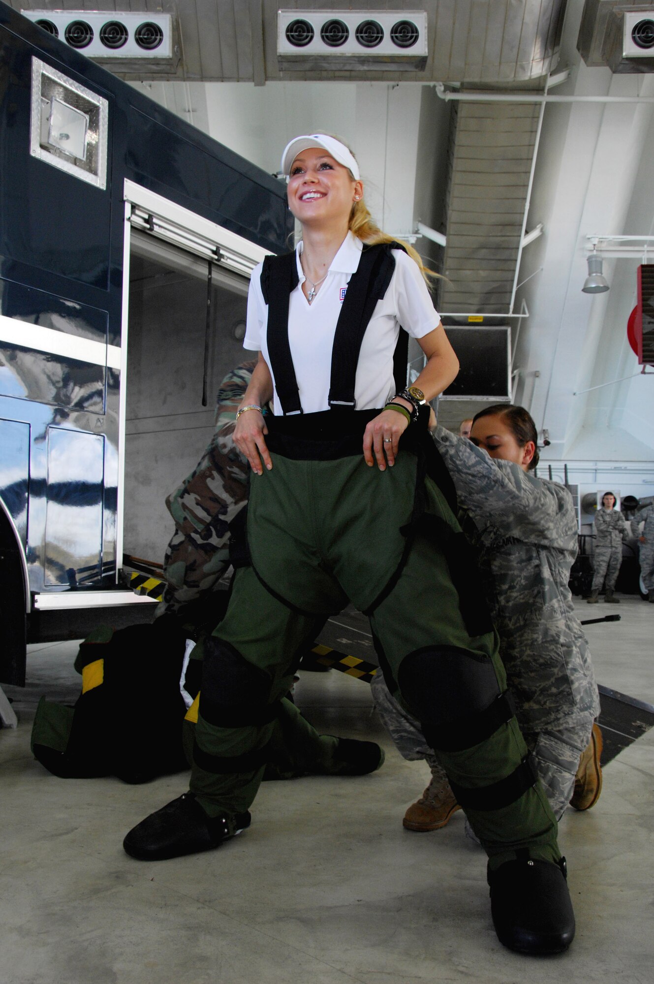 Staff Sgt. Sherri Streu helps Anna Kournikova put on an explosive ordnance disposal bombsuit at Andersen Air Force Base, Guam. Her tour was sponsored by the United Service Organizations to boost morale of servicemembers on Guam. The bombsuit is used by EOD members to prevent injuries and even death during the disposal of explosive ordnances. Sergeant Streu is assigned to the 36th Civil Engineer Squadron. (U.S. Air Force photo/Airman 1st Class Nichelle Griffiths) 
