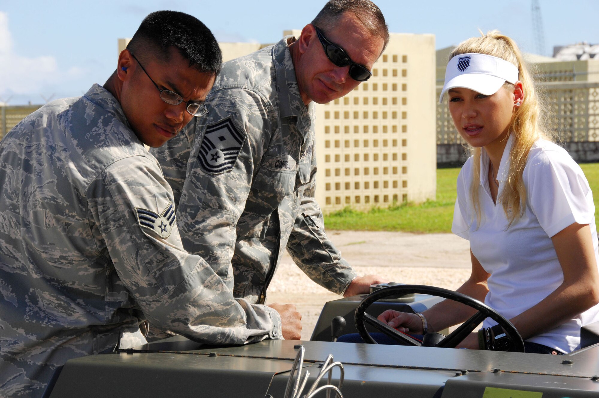 Senior Master Sgt. Paul Cornell and Senior Airman Michael O'Rourkeu show Anna Kournikova how to correctly operate a bomblifter Oct. 29. Ms. Kournikova was on Guam for a two-day tour sponsored by United Service Organizations of Andersen AFB and Naval Base Guam. Sergeant Cornell and Airman O'Rourkeu are assigned to the 36th Maintenance Squadron. (U.S. Air Force photo/Airman 1st Class Nichelle Griffiths) 
