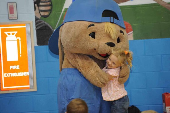 Asia Tague receives a hug for participating in a contest with Sammy Rabbit here, Oct. 30. Sam Renick, author of the book, "It's A Habit, Sammy Rabbit!" visited Ellsworth to teach children how to be financially responsible. (U.S. Air Force photo/Airman 1st Class Adam Grant)
