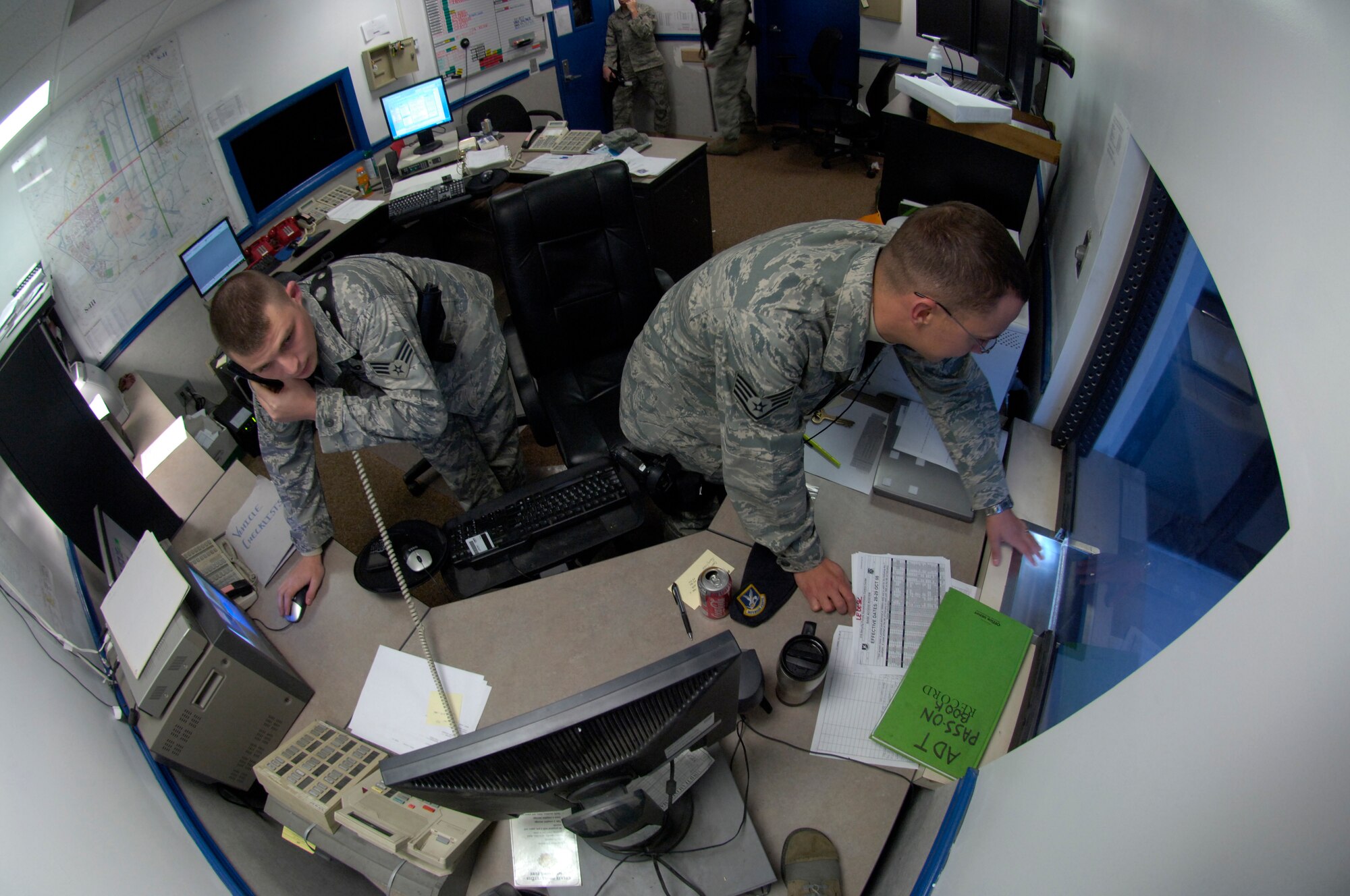 Senior Airman Patrick Harris answers the phone while Staff Sgt. Scott Walker helps a customer at the 316th Security Forces Law Enforcement Desk during the Capital Shield 09 exercise Oct. 29 on Andrews. The LE desk dispatches and monitors all incidents both security and law enforcement. The command post serves as a central focal point for information for the base during attacks, in flight emergencies, and ground emergencies. The exercise consisted of multiple scenarios including suspicious packages, mass casualty training, and terrorist attack procedures. Capital Shield is an annual exercise in the National Capital Region involving civilian and military authorities such as 316th Wing, 779th Medical Group, 89th Airlift Wing, Prince George’s County Fire and Police Departments and Maryland State Police. (U.S. Air Force photo by Senior Airman Renae Kleckner)