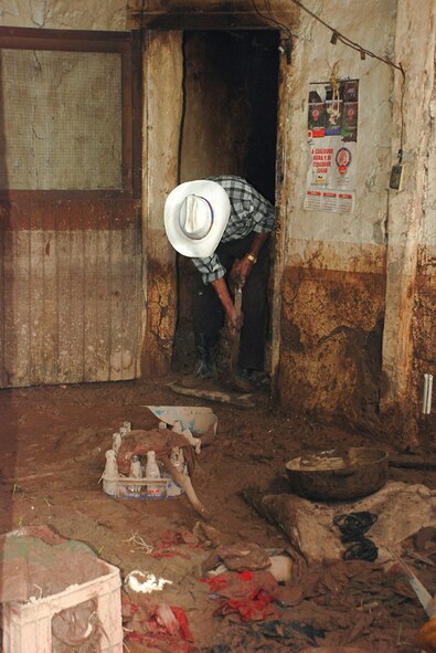 An elderly gentleman begins the process of cleaning his home after floodwaters left his home caked in mud and trash Oct. 29 at La Paz, Honduras. The flooding from a tropical depression in Honduras affected several thousand across Honduras. In this community near Soto Cano Air Base, their well water was left undrinkable. Servicemembers from Joint Task Force-Bravo went to the community to help them purify their water. (U.S. Army photo/Spc. Ethan Anderson)
