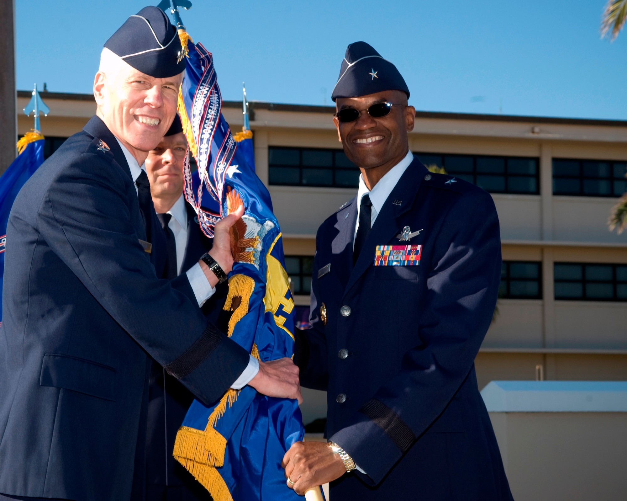 Brig. Gen. Edward L. Bolton, Jr., right, accepts the 45th Space Wing command guidon from Lt. Gen. William L. Shelton, 14th Air Force commander, during a change of command ceremony held Oct. 28 at Memorial Plaza. In between the two generals is Command Chief Master Sgt. Dennis Vannorsdall. Gen. Bolton assumed command from Brig. Gen. Susan J.  Helms. (U.S. Air Force photo by Jim Laviska)