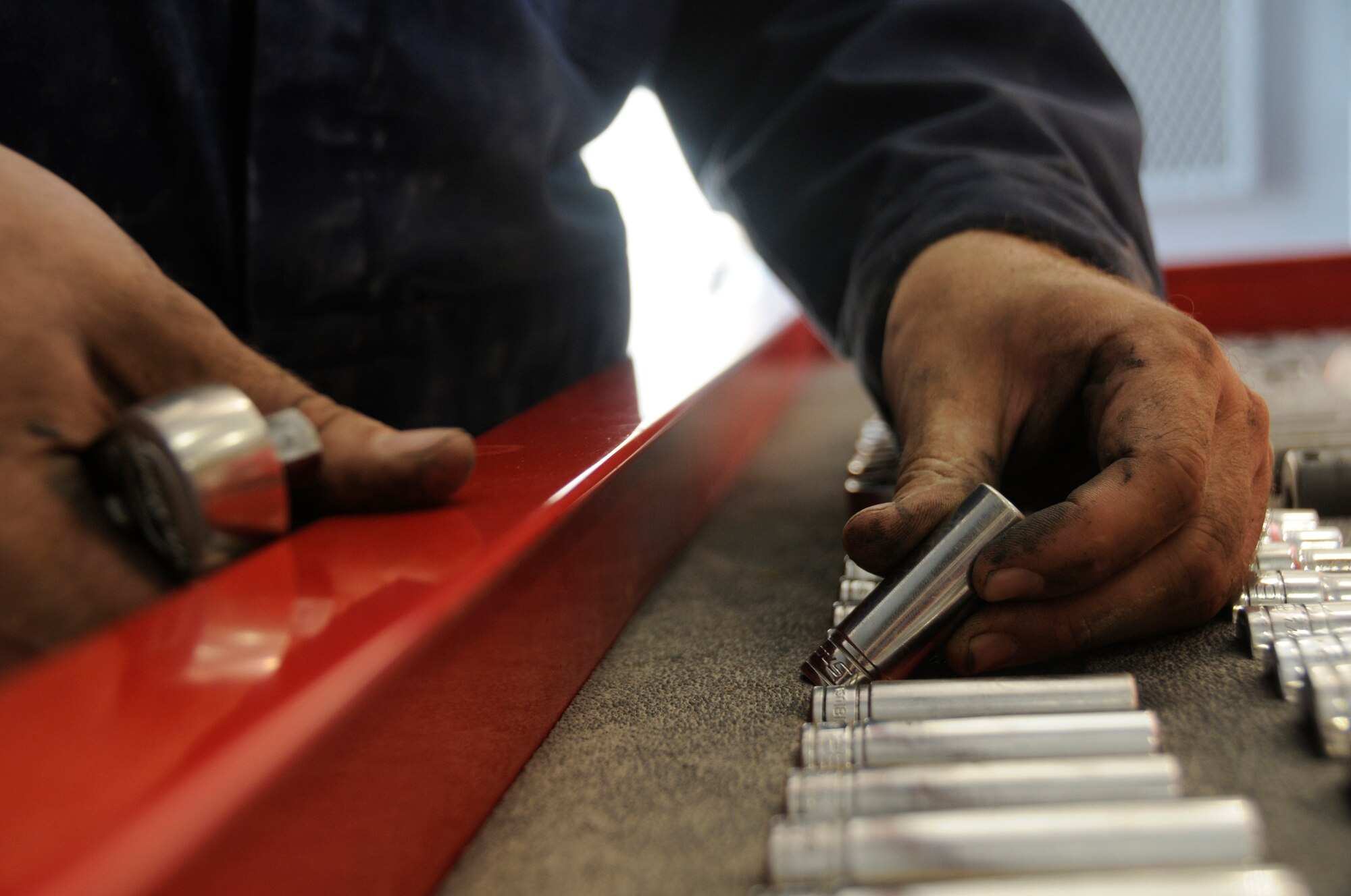 Staff Sgt. William Craddock, aerospace ground equipment craftsman assigned to the 379th Expeditionary Maintenance Squadron, selects a socket for his ratchet Oct. 30, at an undisclosed air base in Southwest Asia. AGE maintainers service and keep operational the ground equipment required to recover and launch aircraft serving the Global War on Terrorism here. Sergeant Craddock, a native of Fairbanks, Alaska, is deployed from Ellsworth Air Force Base, S.D in support of Operations Iraqi and Enduring Freedom and Joint Task Force-Horn of Africa. (U.S. Air Force photo by Staff Sgt. Darnell T. Cannady/Released)