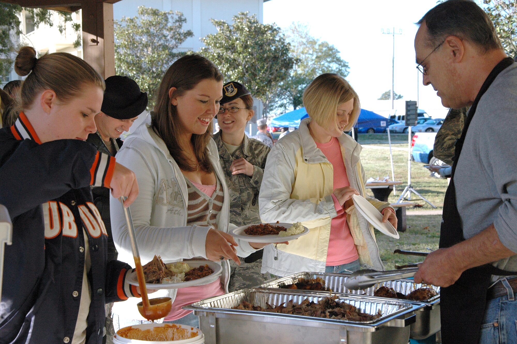 Dorm residing Airmen help themselves to barbecued pork and chicken at the ?Salute Our Troops? barbecue at the dorms on Eglin Air Force Base Oct. 29. The barbecue, provided by the Fort Walton Beach Chamber of Commerce, was held for Airmen living in the dorms in recognition of their service. (U.S. Air Force Photo/Jasmine DeNamur)