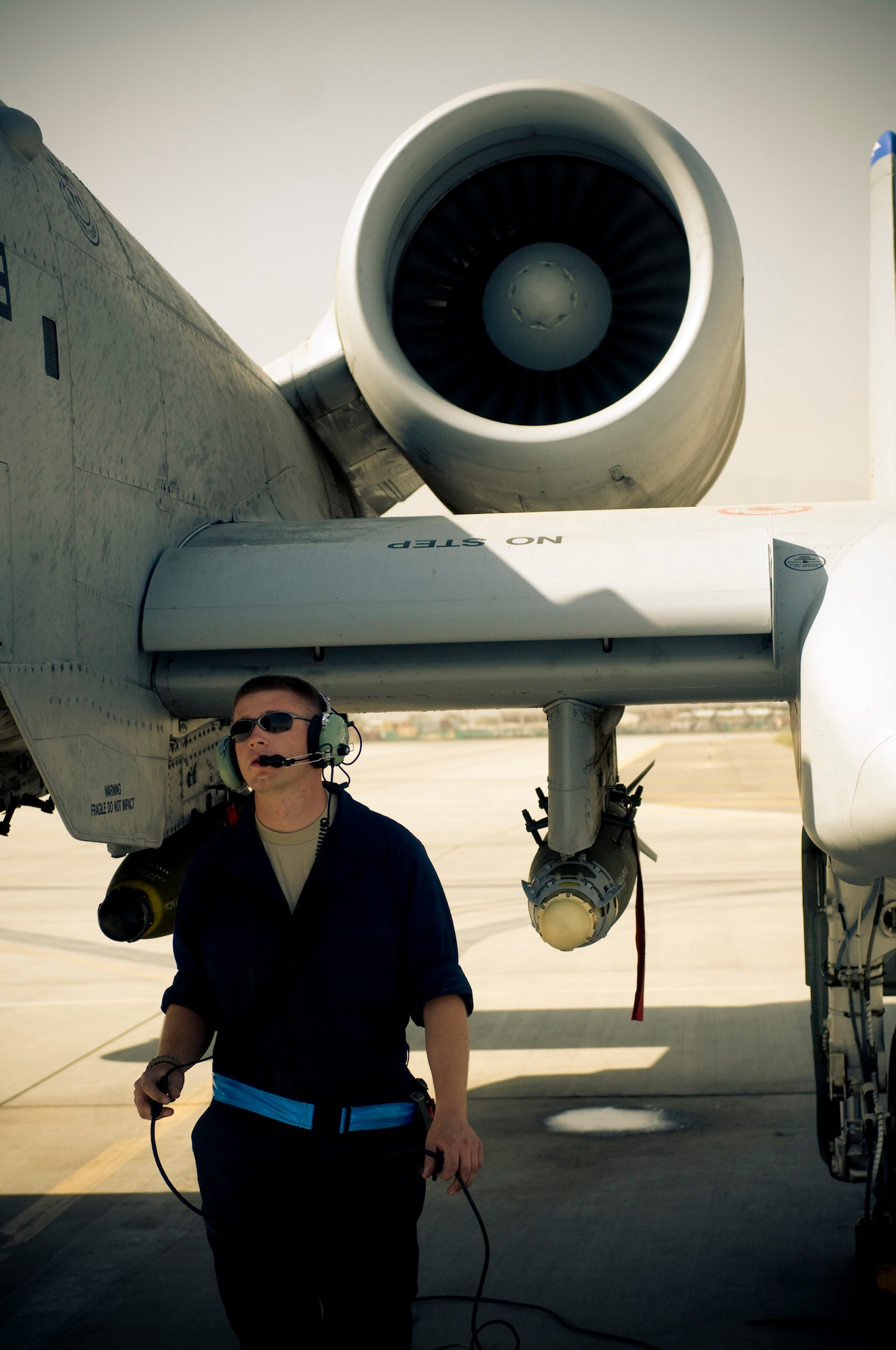 Senior Airman Benjamin Connery, 455th Expeditionary Aircraft Maintenance Squadron A-10 crewchief, walks to the front of an A-10 Thunderbolt II to check the air-refueling door at Bagram Air Field, Afghanistan, Oct. 18. The large turbofan jet engine is "remarkably quiet" according to Airman Connery. He is deployed from the 23rd Aircraft Maintenance Squadron, Moody Air Force Base, Ga., and hails from Cashmere, Wash. (U.S. Air Force photo by Staff Sgt. Samuel Morse/Released)