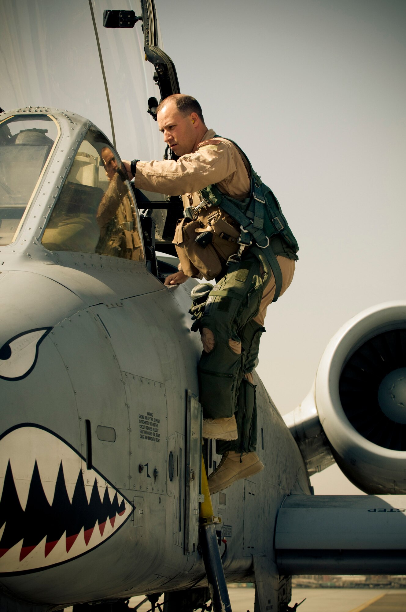 Maj. Erik Knauff, 455th Air Expeditionary Wing flight safety officer and pilot, climbs into an A-10 Thunderbolt II at Bagram Air Field, Afghanistan, Oct. 18. The A-10s, unlike the F-15E Strike Eagles here, only have a one-man crew as opposed to a separate weapons systems officer. Major Knauff is deployed from Moody Air Force Base, Ga., and hails from Perry Hall, Md. (U.S. Air Force photo by Staff Sgt. Samuel Morse/Released)