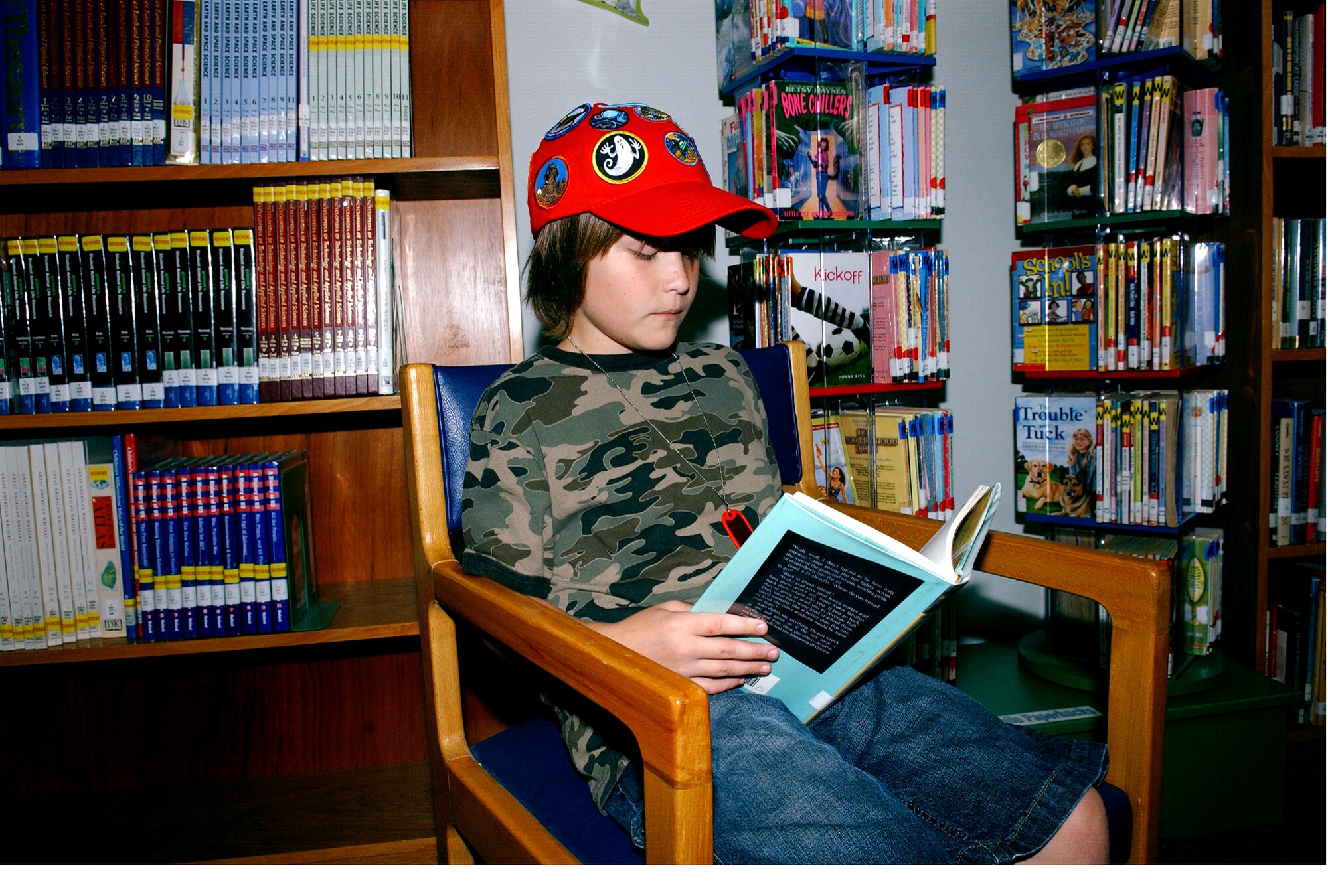 Colby Gill, 9, son of Master Sgt. Robert and Patricia Gill, reads a book at the 39th Force Support Squadron library while participating in the Incirlik Reading Patch Club.  Children earn a patch for every three books they read.  The program is designed to get children excited about reading.  (U.S. Air Force Photo/Staff Sgt. Chris Galindo)