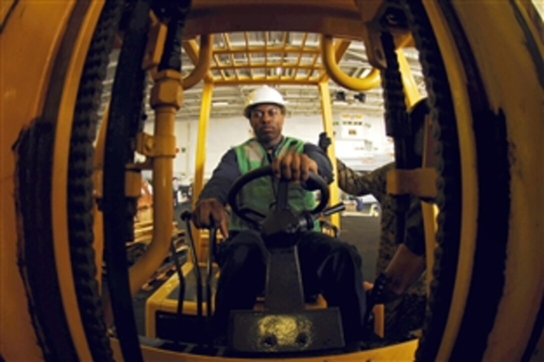 U.S. Navy Seaman Jeremy Donaldso moves supplies in the hangar bay of the aircraft carrier USS John C. Stennis during a replenishment at sea in the Pacific Ocean, Oct. 28, 2008. 