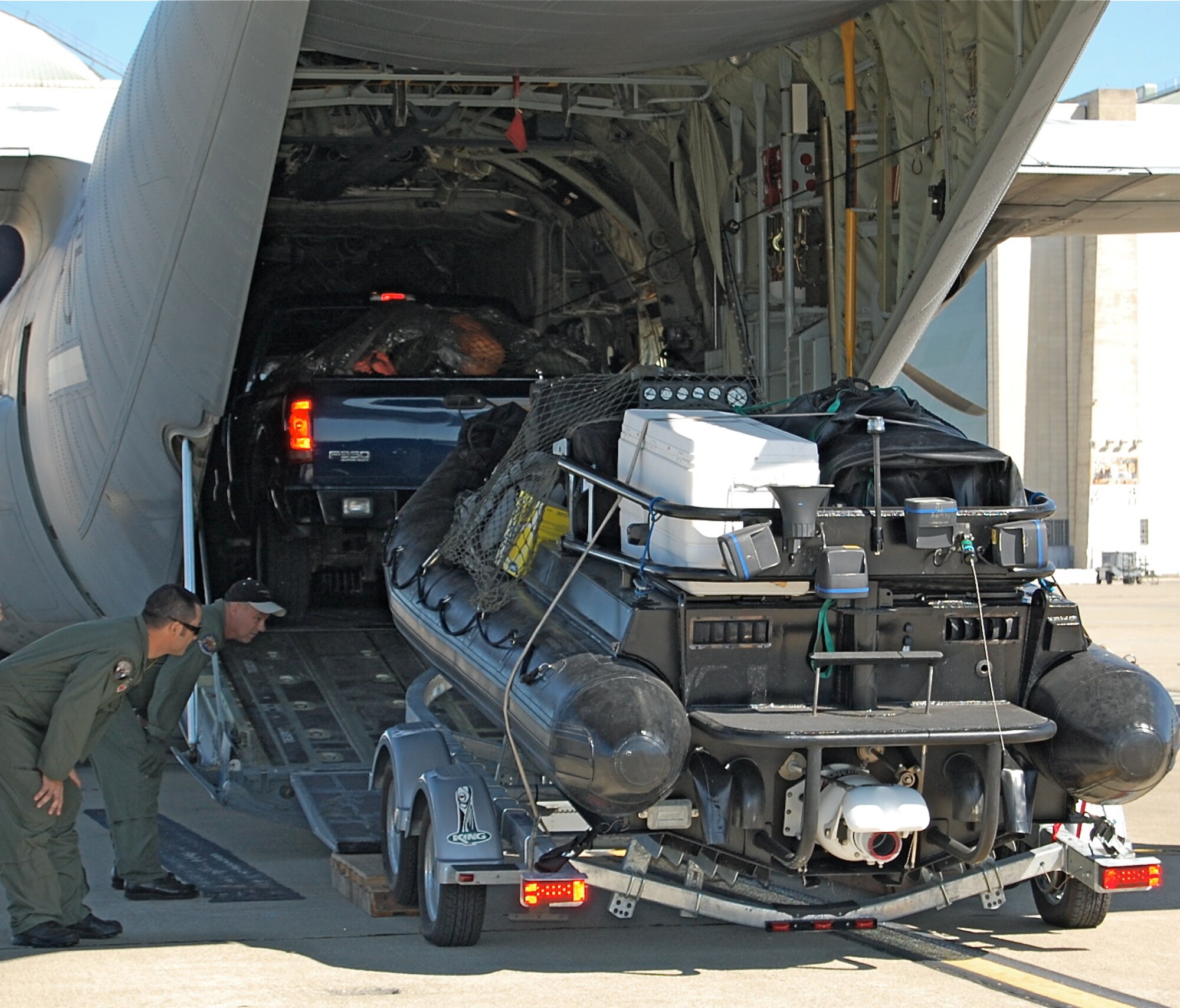Chief Master Sgt. Charles Dehart (black hat), a loadmaster from the 146th Airlift Wing and a PJ from the 129th Rescue Wing spot the tires of an on-boarding truck filled with rescue equipment.  PJs from the 129th Rescue Wing loaded various equipment in preparation of the possible aftermath of Hurricane Gustav. (U.S. Air Force photo by Staff Sgt. Jill Jamgochian)
