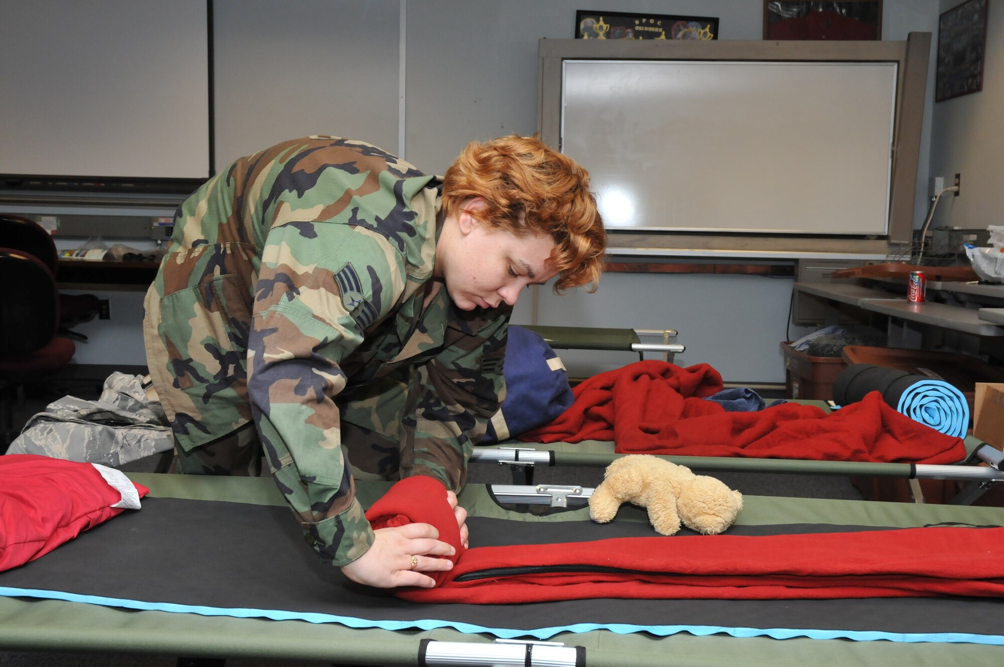 Senior Airman Michelle Clark with the 81st Operations Support Flight rolls up her bed after a good night's sleep in a shelter on base.  Airman Clark, along with more than 750 Keesler non-prior students, rapid recovery team members and storm recovery-essential personnel sheltered from the effects of Hurricane Gustav in Wolfe Hall, one of Keesler's designated hurricane shelters (U.S. Air Force photo by Adam Bond).