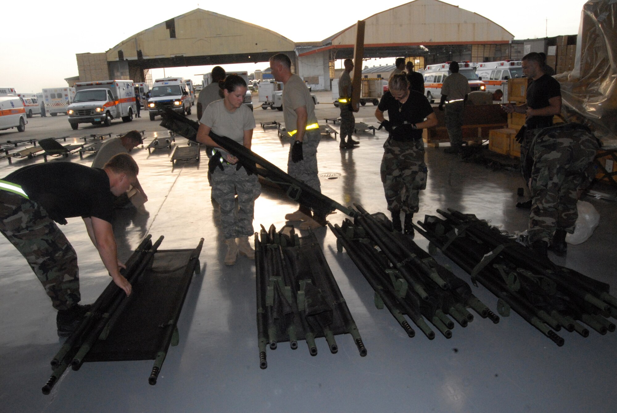 Airmen from the 43rd Aeromedical Evacuation Squadron and 43rd Medical Group, Pope Air Force Base, N.C., build litters in preparation for patient arrival at Lakefront Airport in Louisiana on the evening of August 30. Pope Airmen treated more than 100 patients at the airport on August 30 and 31. (U.S. Air Force photo/Airman 1st Class Mindy Bloem)