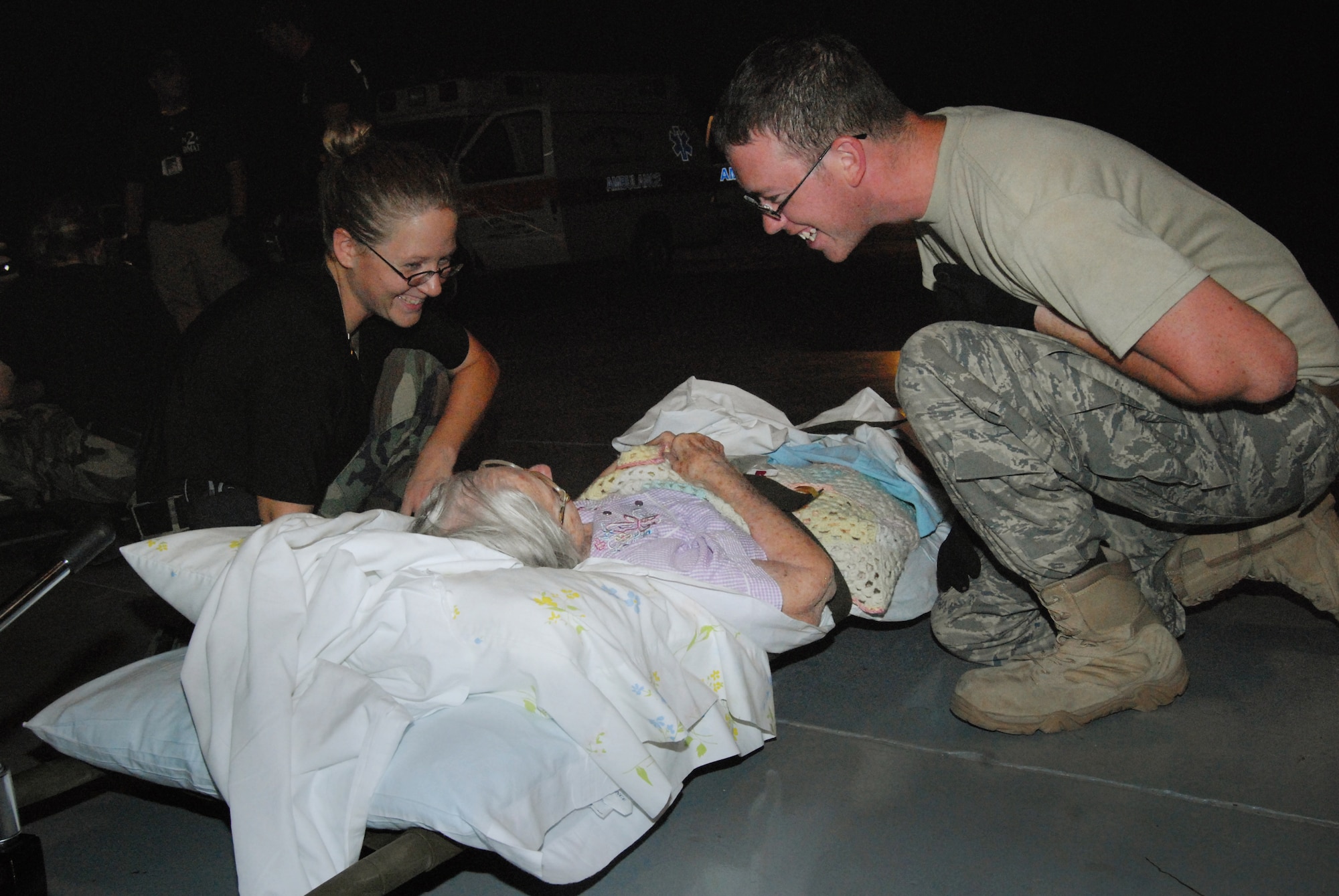 Tech. Sgt. Krystal Marks, 43rd Aerospace Medicine Squadron and Senior Airman Payden Forkum, 43rd Medical Operations Squadron, provide care to an elderly woman at the Lakefront Airport in Louisiana August 31. (U.S. Air Force photo/Airman 1st Class Mindy Bloem)