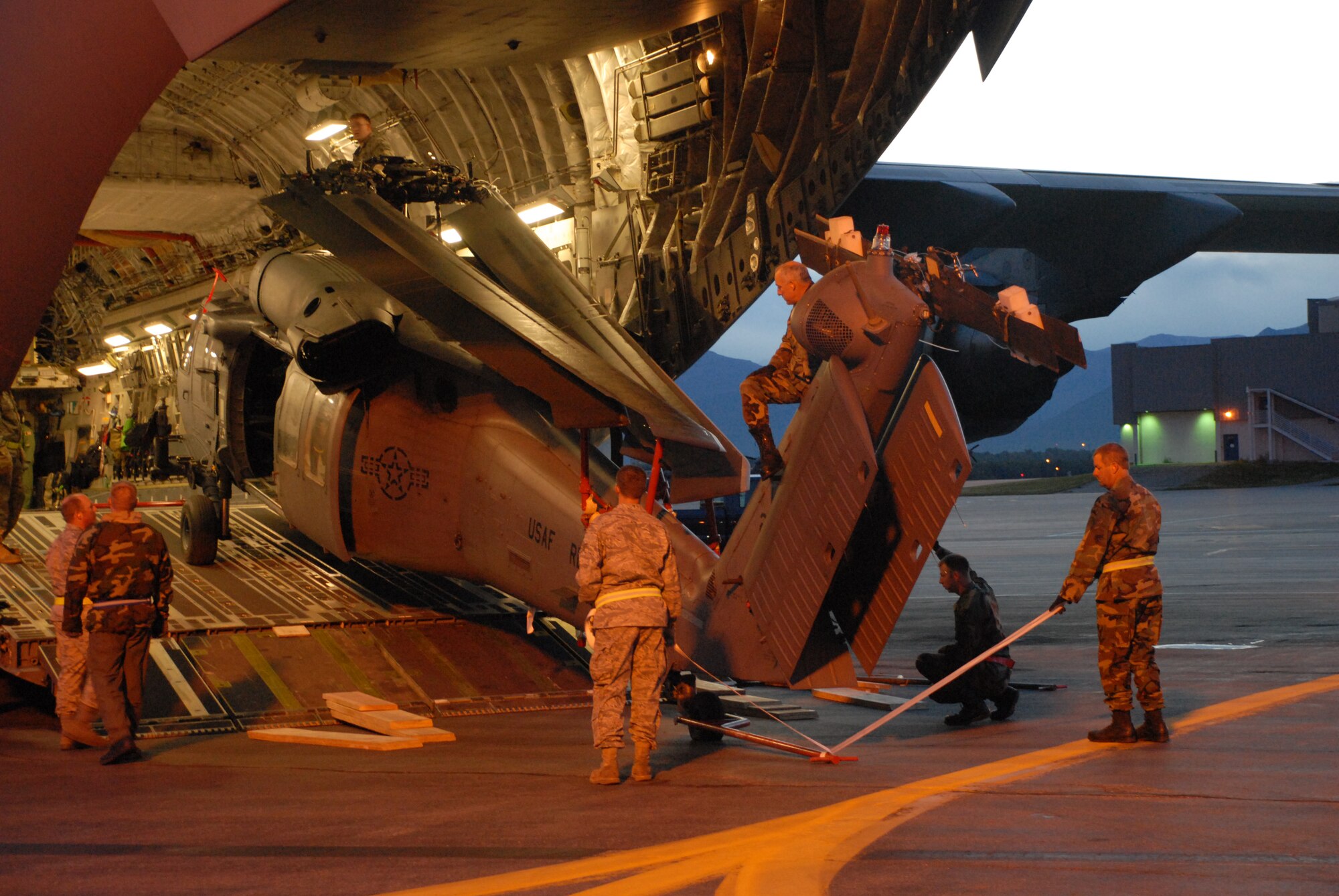 KULIS AIR NATIONAL GUARD BASE, Alaska -- In the early morning hours of Sept. 1, 2008, Alaska Air National Guardsmen from the 176th Logistics Readiness Squadron maneuver an HH-60 Pave Hawk helicopter onto the loading ramp of a C-17 strategic airlift jet. The helicopter is one of two the Alaska Air National Guard?s 176th Wing is deploying to the Gulf Coast region to support possible search-and-rescue operations expected in the wake of Hurricane Gustav. Approximately 30 wing members have deployed to the region as well. Alaska Air National Guard photo by 2nd Lt. John Callahan.