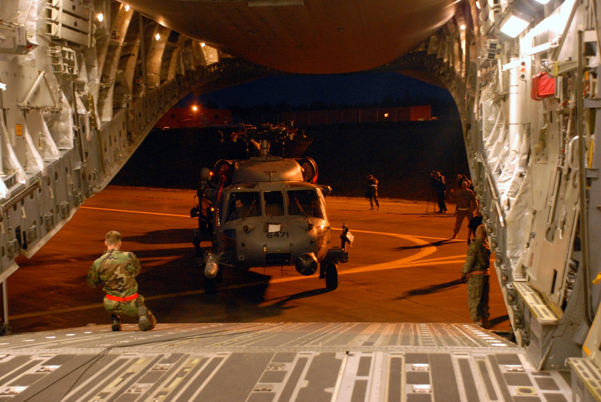 KULIS AIR NATIONAL GUARD BASE, Alaska -- In the early morning hours of Sept. 1, 2008, Alaska Air National Guardsmen from the 176th Logistics Readiness Squadron maneuver an HH-60 Pave Hawk helicopter onto the loading ramp of a C-17 strategic airlift jet. The helicopter is one of two the Alaska Air National Guard?s 176th Wing is deploying to the Gulf Coast region to support possible search-and-rescue operations expected in the wake of Hurricane Gustav. Approximately 30 wing members have deployed to the region as well. Alaska Air National Guard photo by 2nd Lt. John Callahan.