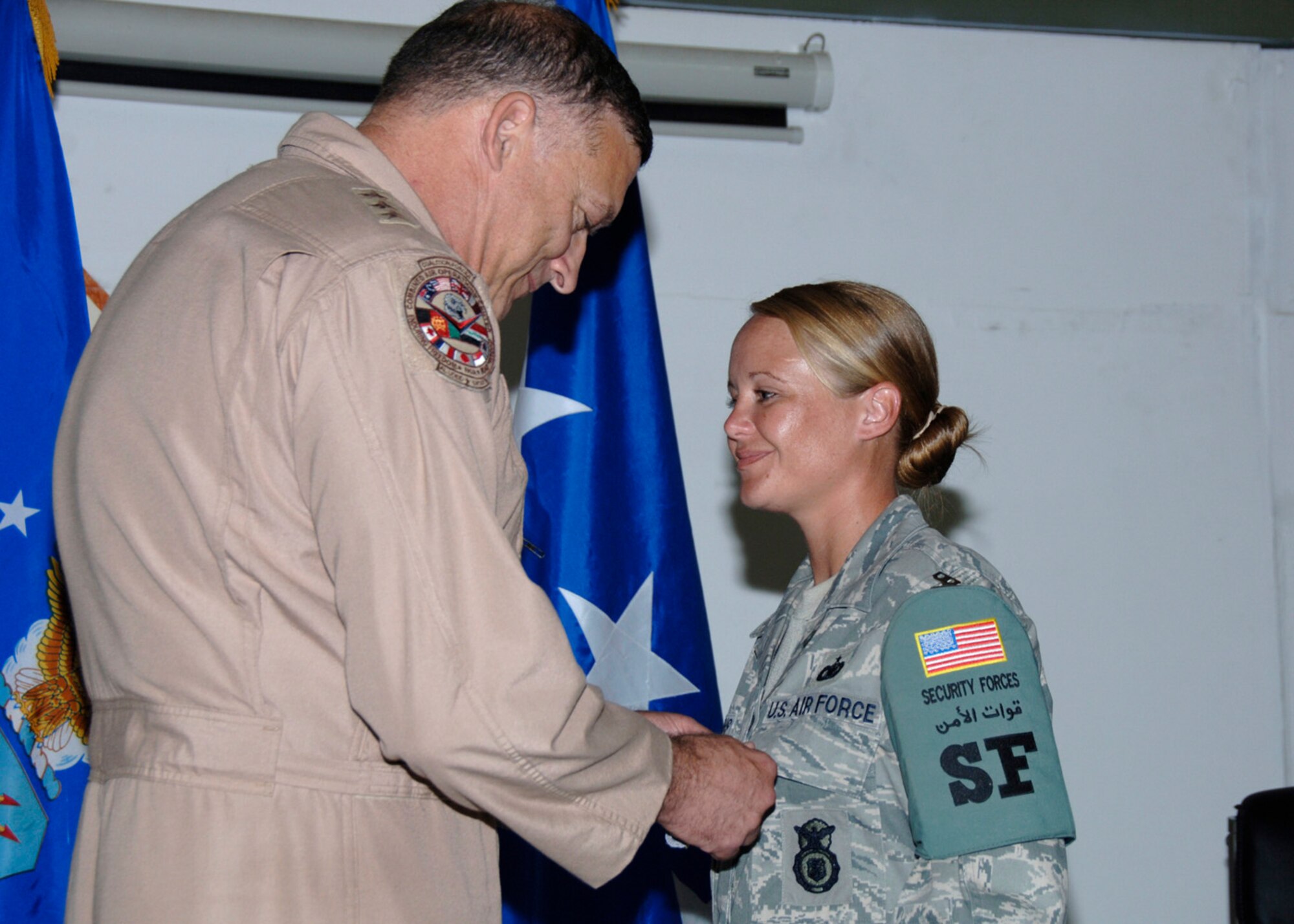 SOUTHWEST ASIA -- Lt. Gen. Gary North U.S. Air Forces Central Commander presents Staff Sgt. Virginia Ganus from the 380th Expeditionary Security Forces Squadron the Air Force Comabt Action Medal here Aug. 31. She recieved the medal for her actions during a combat convoy in Kirkuk regional Air Base, Iraq. Sergeant Ganus is deployed from Pope Air Force Base, N.C. her hometown is Roanoke, Va.(U.S. Air Force photo/Tech. Sgt. Christopher A Campbell)(released)