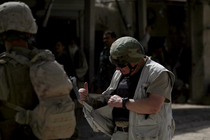 Ralph E. Morten, a senior advisor for counter-insurgency with Lockheed Martin, shows a Marine assigned to Company E, Task Force 2d Battalion, 7th Marine Regiment, 1st Marine Division, Combined Joint Task Force Phoenix, some wire and other components necessary to construct an improvised explosive device that he was able to purchase in a local bazaar, Sept. 1. Morten, a 34-year veteran of the Los Angeles Police Department, came to Sangin to teach Echo Company Marines the methods of patrolling the streets like a police officer. (U.S. Marine Corps photo by Cpl. Steve Cushman)