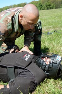 Airman 1st Class Antonio D'Errico, from the 436th Security Forces Squadron, Dover Air Force Base, Del., and a student in the Air Force Phoenix Raven Course, checks the injury status of a "downed agressor during an evaluation session in the course on a Fort Dix, N.J., range Aug. 20, 2008.  The course, taught by the U.S. Air Force Expeditionary Center's 421st Combat Training Squadron, trains security forces Airmen to become Ravens where they specialize in protecting Air Force aircraft in austere environments.  (U.S. Air Force Photo/Tech. Sgt. Scott T. Sturkol)